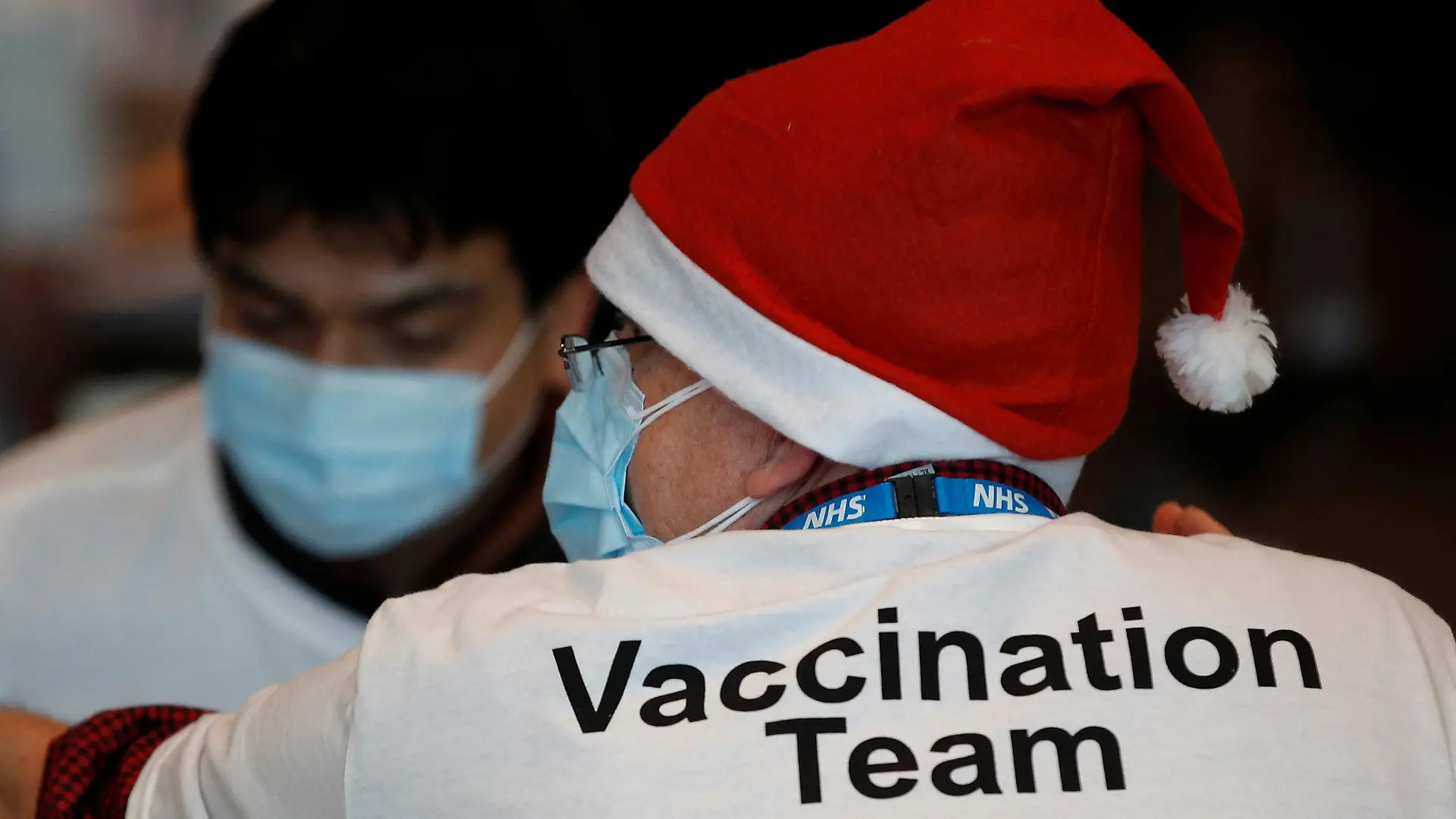 A healthcare professional wears a Santa Claus hat at a coronavirus disease (COVID-19) pop-up vaccination centre at Wembley Stadium in London, Britain, December 19, 2021. REUTERS/Peter Nicholls