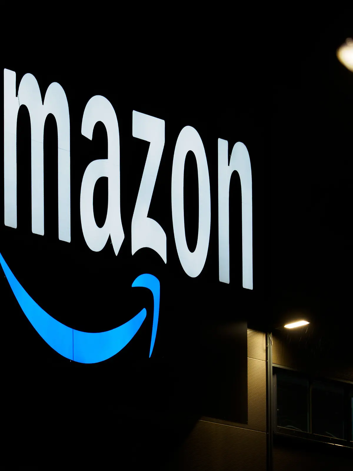 ARCHIV - 17.12.2020, Brandenburg, Schönefeld/Ot Kiekebusch: Das Amazon-Logo ist auf der Fassade eines Sortierzentrums zu sehen. Die italienischen Wettbewerbshüter haben gegen Amazon eine Milliardenstrafe wegen Missbrauchs seiner Marktposition verhängt. (zu dpa «Italiens Kartellbehörde verhängt Milliardenstrafe gegen Amazon») Foto: Soeren Stache/dpa-Zentralbild/dpa +++ dpa-Bildfunk +++