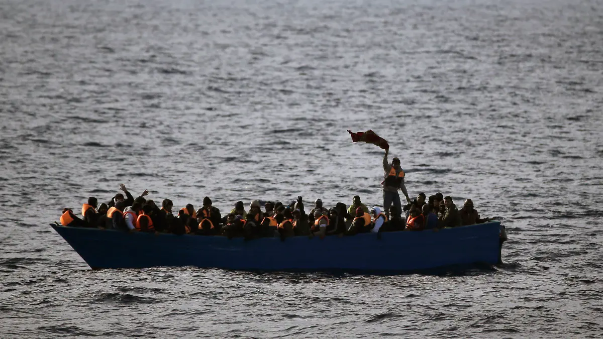 ARCHIV - 03.02.2017, ---: Flüchtlinge aus Afrika rufen auf dem Mittelmeer in einem Boot um Hilfe. (ILLUSTRATION zu dpa "115 Migranten nach Bootsunglück im Mittelmeer vermisst") Foto: Emilio Morenatti/AP/dpa +++ dpa-Bildfunk +++