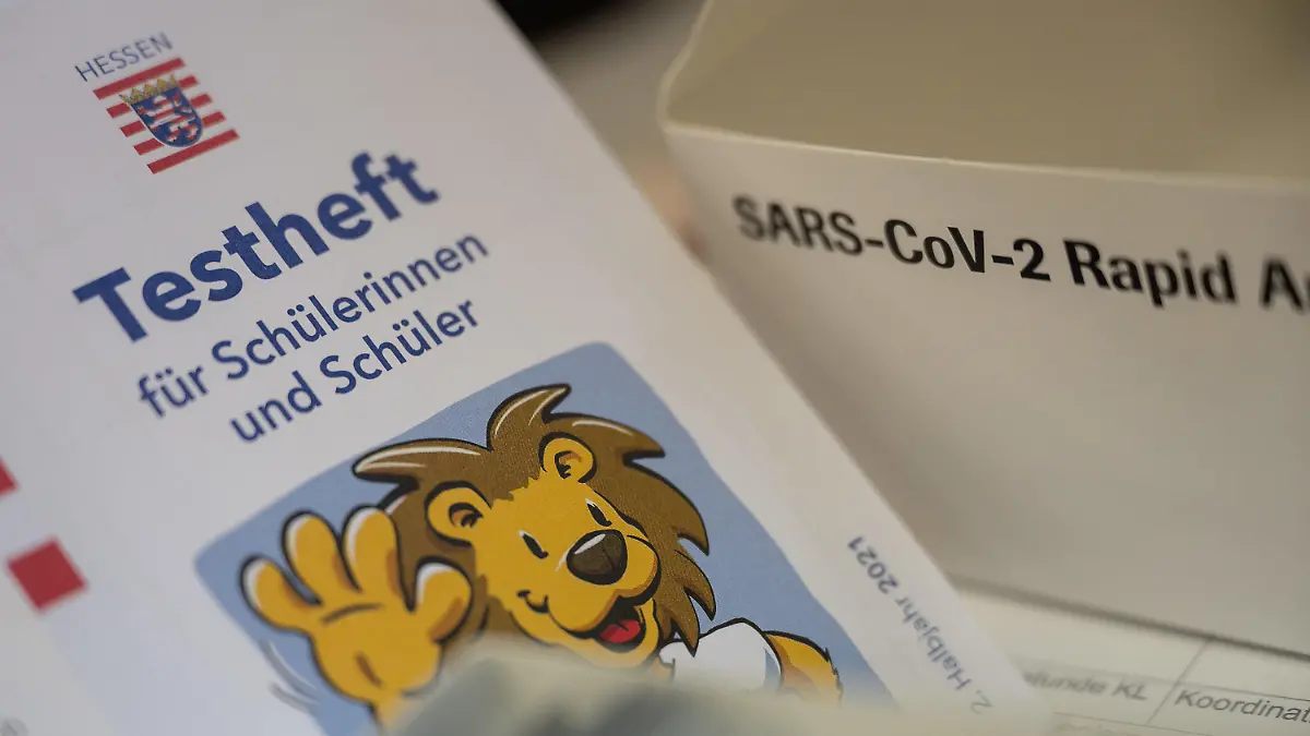 ARCHIV - 30.08.2021, Hessen, Nidda: Ein Testheft für Schülerinnen und Schüler liegt vor der ersten Stunde an einer Schule neben einer Schachtel mit Corona-Schnelltests. (zu dpa «Corona-Tests in Hessen nach Schulstart») Foto: Sebastian Gollnow/dpa +++ dpa-Bildfunk +++