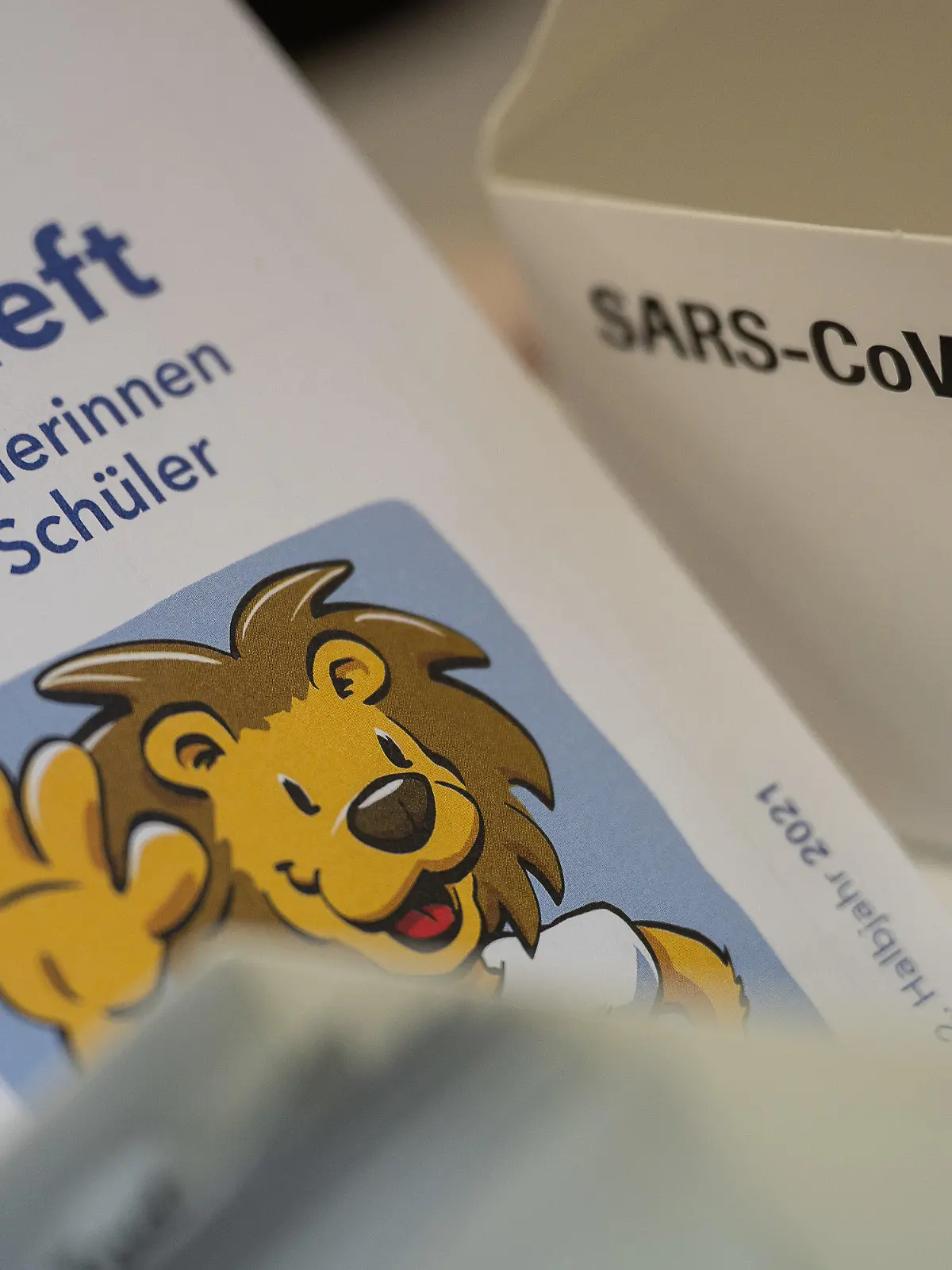 ARCHIV - 30.08.2021, Hessen, Nidda: Ein Testheft für Schülerinnen und Schüler liegt vor der ersten Stunde an einer Schule neben einer Schachtel mit Corona-Schnelltests. (zu dpa «Corona-Tests in Hessen nach Schulstart») Foto: Sebastian Gollnow/dpa +++ dpa-Bildfunk +++