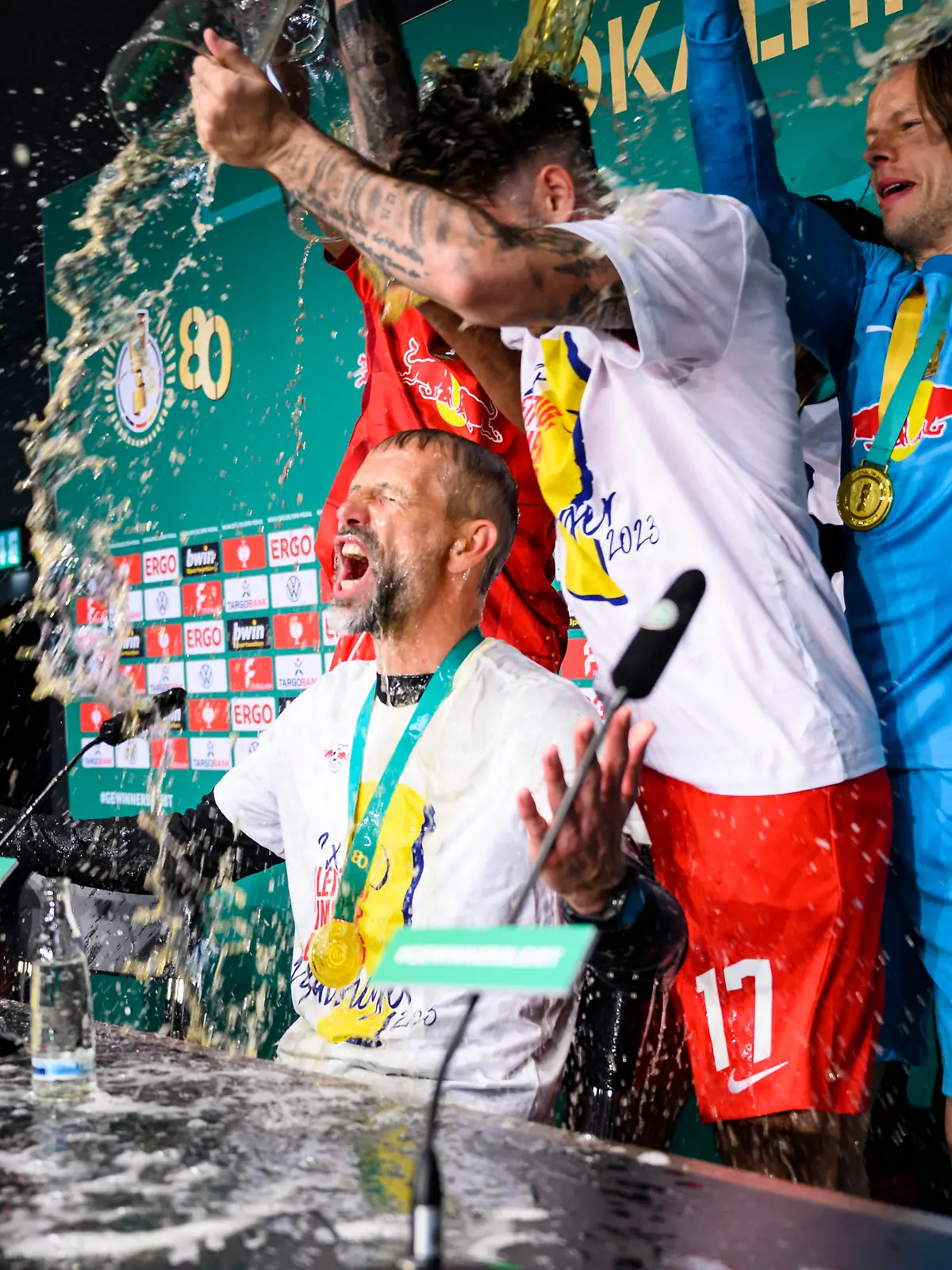 Fußball: DFB-Pokal, RB Leipzig - Eintracht Frankfurt, Finale, Olympiastadion. Leipzigs Cheftrainer Marco Rose wird bei der Pressekonferenz mit Bier begossen.