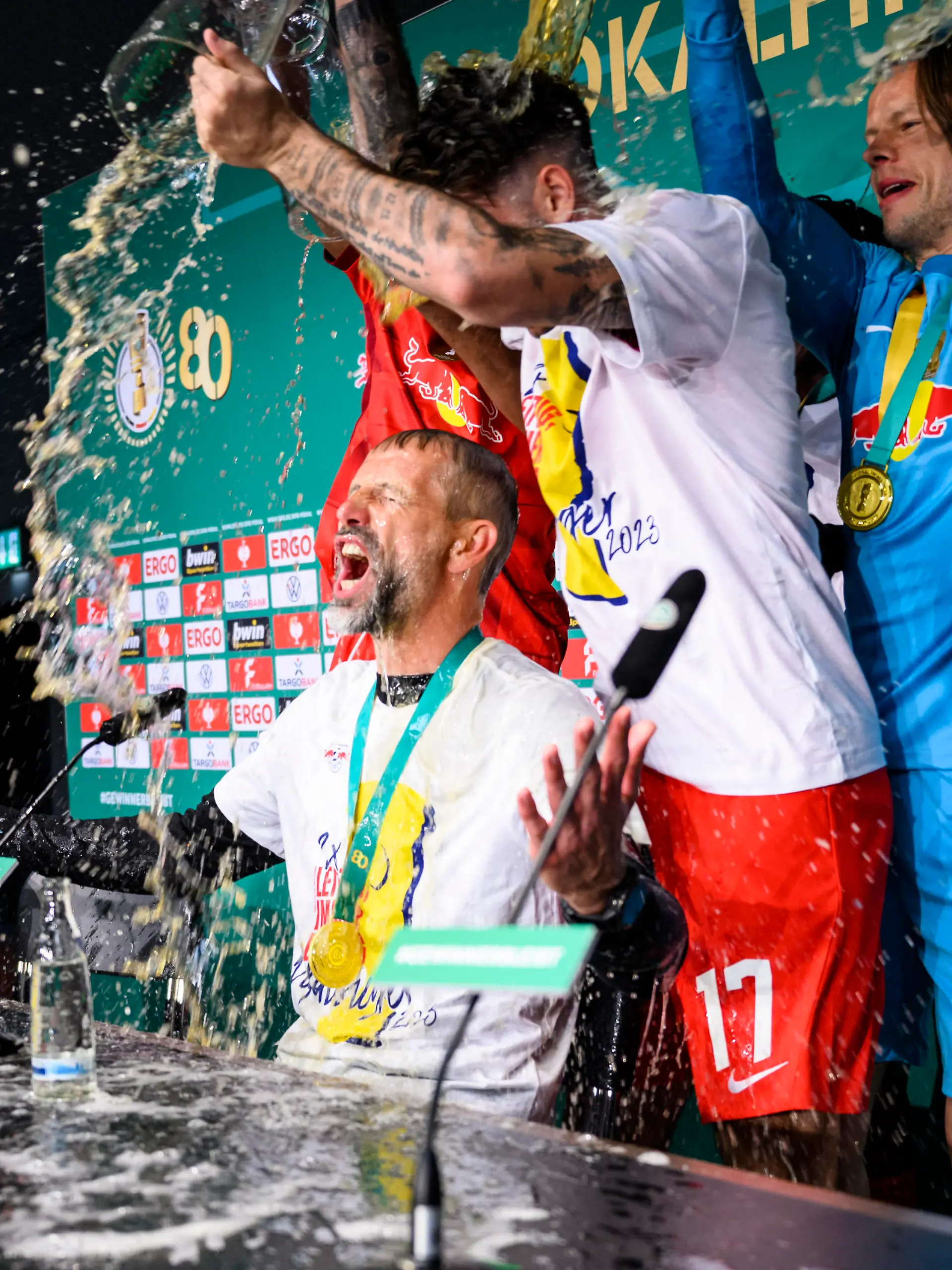 Fußball: DFB-Pokal, RB Leipzig - Eintracht Frankfurt, Finale, Olympiastadion. Leipzigs Cheftrainer Marco Rose wird bei der Pressekonferenz mit Bier begossen.