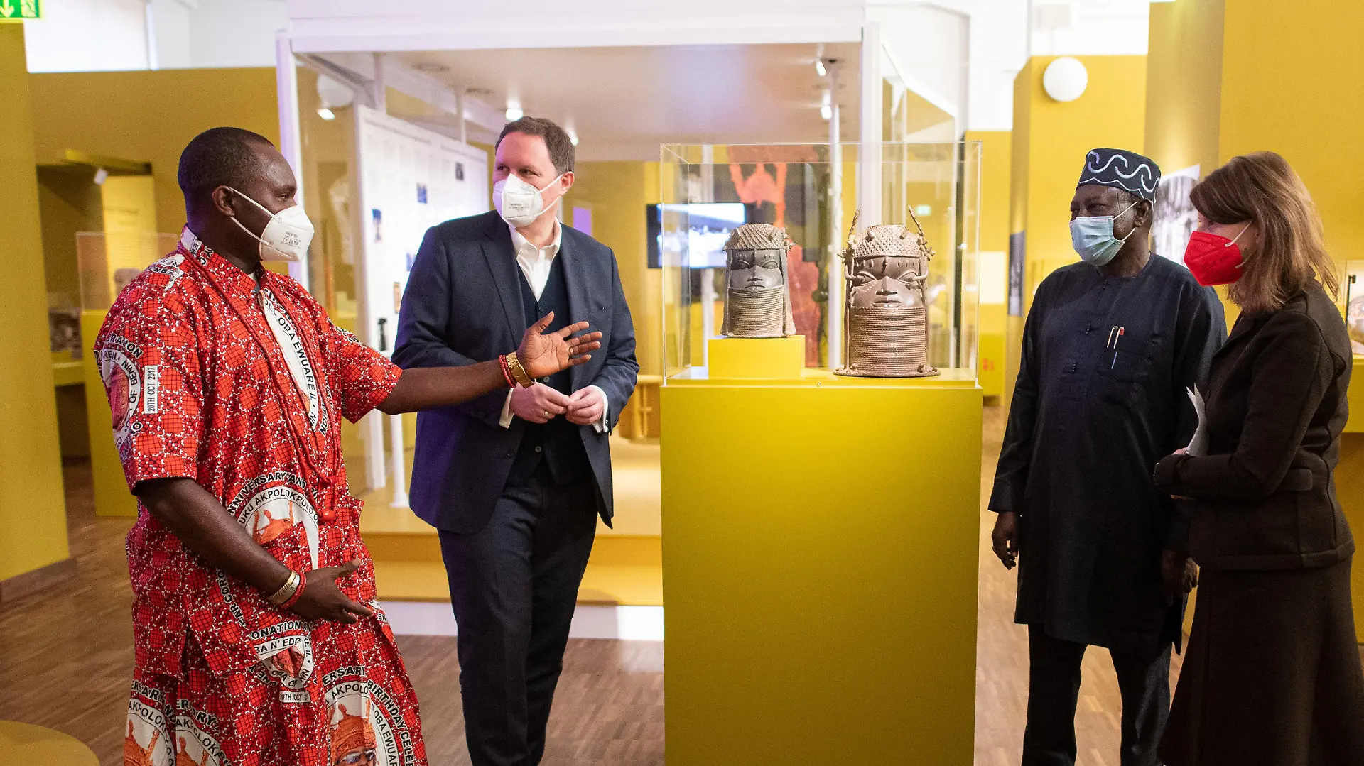 16.12.2021, Hamburg: Osaisonor Godfrey Ekhator-Obogie (l-r), Mitglied des kuratorischen Teams, Carsten Brosda (SPD), Kultursenator von Hamburg, Abba Isa Tijani, Generaldirektor der National Commission for Museums and Monuments, und Barbara Plankensteiner, Direktorin des Museums am Rothenbaum stehen um zwei Gedenkköpfe eines Königs aus einer Unbekannten Werkstatt der Bronzegießergilde Igun Eronmwon (Königreich Benin, Nigeria, 19. Jahrhundert) in der Ausstellung «Benin. Geraubte Geschichte» im Museum am Rothenbaum. (zu dpa «Museum am Rothenbaum zeigt «Benin-Bronzen» vor Rückgabe») Foto: Daniel Reinhardt/dpa - ACHTUNG: Nur zur redaktionellen Verwendung im Zusammenhang mit einer Berichterstattung über die Ausstellung und nur mit vollständiger Nennung des vorstehenden Credits +++ dpa-Bildfunk +++