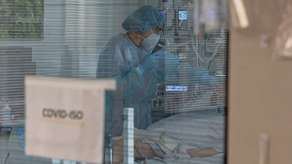 ARCHIV - 26.12.2020, Nordrhein-Westfalen, Aachen: Eine Pflegerin versorgt in der Intensivstation des Luisenhospitals einen Coronapatienten. (zu dpa «Fast so viele Corona-Intensivpatienten wie Ende Dezember») Foto: Henning Kaiser/dpa +++ dpa-Bildfunk +++