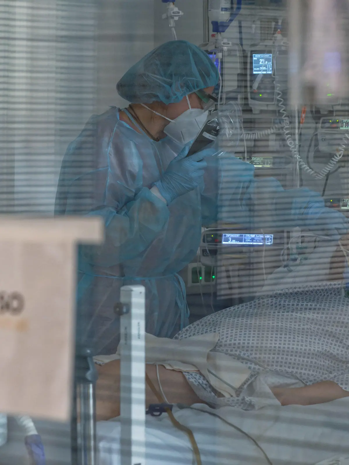 ARCHIV - 26.12.2020, Nordrhein-Westfalen, Aachen: Eine Pflegerin versorgt in der Intensivstation des Luisenhospitals einen Coronapatienten.     (zu dpa «Fast so viele Corona-Intensivpatienten wie Ende Dezember») Foto: Henning Kaiser/dpa +++ dpa-Bildfunk +++