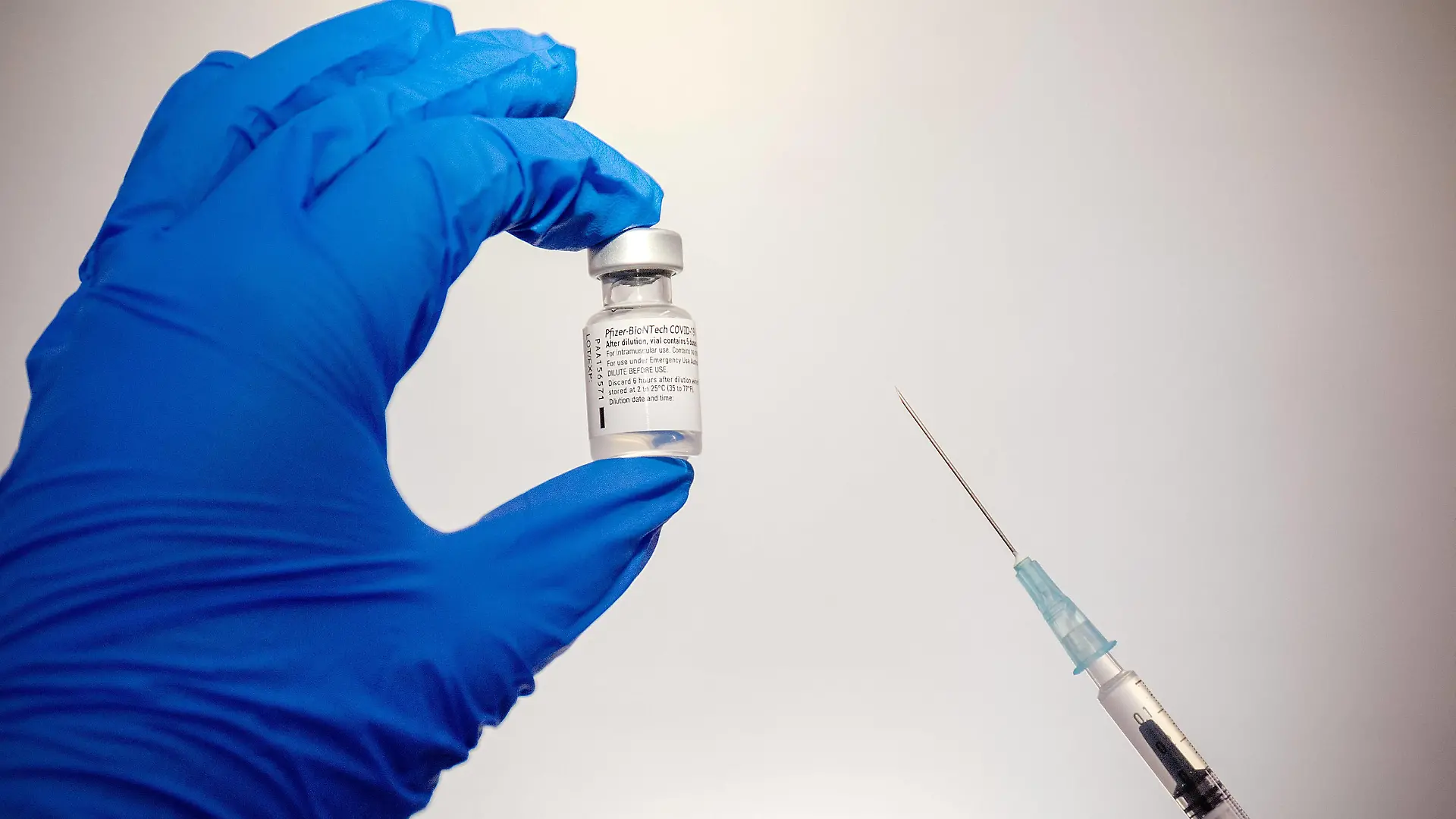 Duesseldorf, Deutschland 02. Februar 2021: Eine Ampulle mit dem Impfstoff gegen Covid-19 von Pfizer-BioNTech wird in der linken Hand gehalten und die Spritze mit dem aufgezogenen Impfstoff Nordrhein Westfalen *** Duesseldorf, Germany 02 February 2021 An ampoule containing Pfizer BioNTechs Covid 19 vaccine is held in the left hand and the syringe with the vaccine drawn up Nordrhein Westfalen Copyright: xFotostandx/xWundrigx