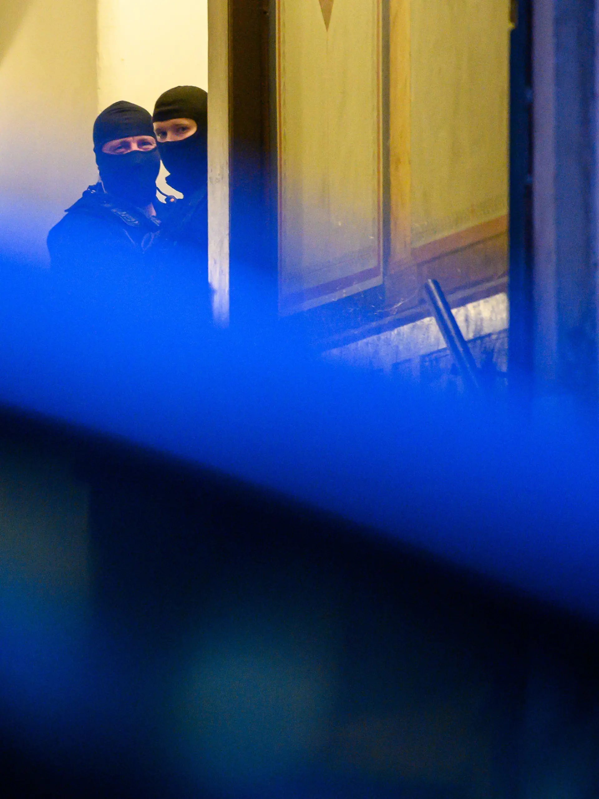 15.12.2021, Sachsen, Dresden: Polizisten stehen während einer Razzia in einem Haus im Stadtteil Pieschen. Nach Drohungen gegen Sachsens Ministerpräsidenten Kretschmer auf Telegram durchsucht die Polizei in Dresden mehrere Objekte. Beteiligt seien auch Spezialkräfte des Landeskriminalamts (LKA), da Äußerungen einzelner Mitglieder der Telegram-Gruppe den Verdacht nahe legten, dass diese im Besitz von scharfen Waffen und Armbrüsten sein könnten, teilte die Polizei auf Twitter mit. Foto: Robert Michael/dpa-Zentralbild/dpa +++ dpa-Bildfunk +++