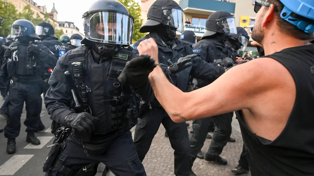03.06.2023, Sachsen, Leipzig: Bei Protesten gegen das Urteil im Prozess gegen Lina E. in Leipzig rangeln Polizisten und ein Demonstranten. Das Oberlandesgericht Dresden hatte die Studentin Lina E. zu fünf Jahren und drei Monaten Freiheitsstrafe verurteilt. Seit langem wird in der linken Szene für den sogenannten «Tag X» mobilisiert. Foto: Robert Michael/dpa +++ dpa-Bildfunk +++