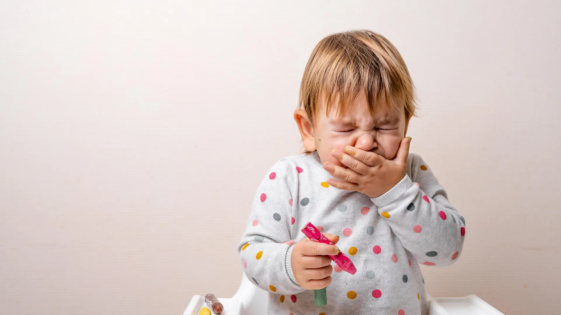 Toddler child sneezing while drying with crayons. Baby with allergy or cold from daycare or kindergarten. Germs paediatric medicine. High quality photo || Modellfreigabe vorhanden