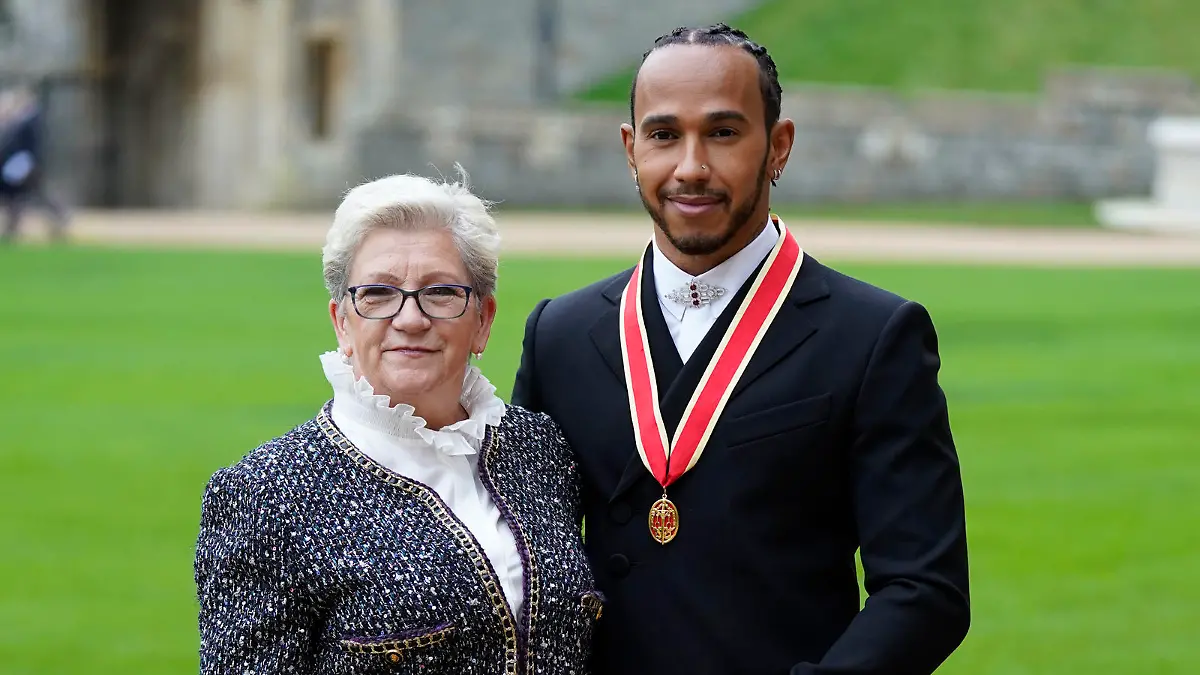 Lewis Hamilton with his mother Carmen Lockhart poses for the media after he was made a Knight Bachelor by Britain's Prince Charles during a investiture ceremony at Windsor Castle in Windsor, England, Wednesday, Dec. 15, 2021. (Andrew Matthews/Pool Photo via AP)