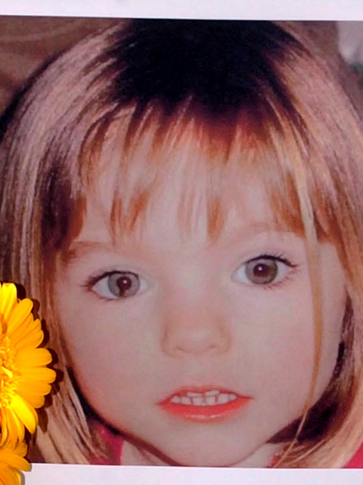 ARCHIV - 12.05.2007, Portugal, Lagos: Blumen stehen vor einem Bild, das die verschwundene Madeleine McCann (Maddie) auf einem Foto zeigt, das ihre Eltern im Zusammenhang mit dem Verschwinden des Kindes veröffentlich haben. Gut 16 Jahre nach dem Verschwinden der damals dreijährigen Madeleine McCann im Süden Portugals will die Polizei Medienberichten zufolge eine neue Suchaktion starten. (zu dpa "Medien: Polizei will in Portugal wieder nach Maddie suchen") Foto: Luis Forra/LUSA/epa/dpa +++ dpa-Bildfunk +++