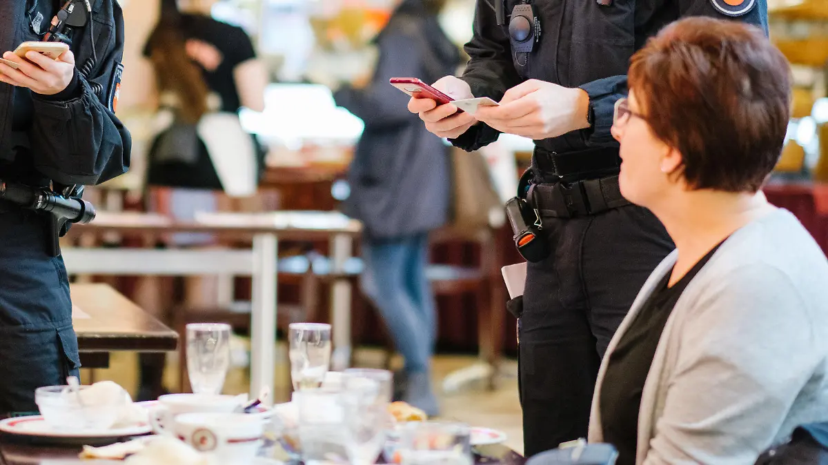 dpatopbilder - 29.11.2021, Niedersachsen, Hannover: Beamte der Bereitschaftspolizei kontrollieren die Impfnachweise von Restaurantgästen während einer Corona-Kontrolle. Die Polizei führte gemeinsam mit dem Ordnungsamt Hannover Corona-Kontrollen in Gastronomiebetrieben in der Innenstadt durch. Foto: Ole Spata/dpa +++ dpa-Bildfunk +++
