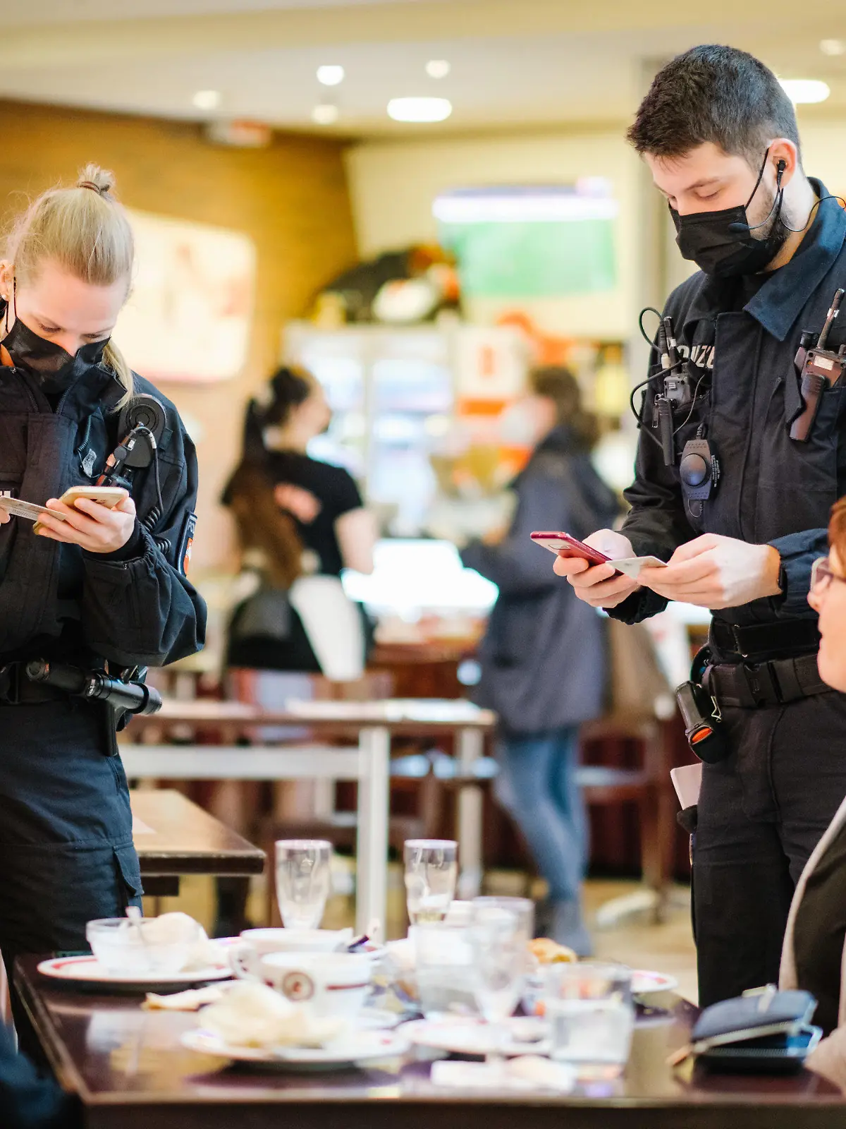 dpatopbilder - 29.11.2021, Niedersachsen, Hannover: Beamte der Bereitschaftspolizei kontrollieren die Impfnachweise von Restaurantgästen während einer Corona-Kontrolle. Die Polizei führte gemeinsam mit dem Ordnungsamt Hannover Corona-Kontrollen in Gastronomiebetrieben in der Innenstadt durch. Foto: Ole Spata/dpa +++ dpa-Bildfunk +++