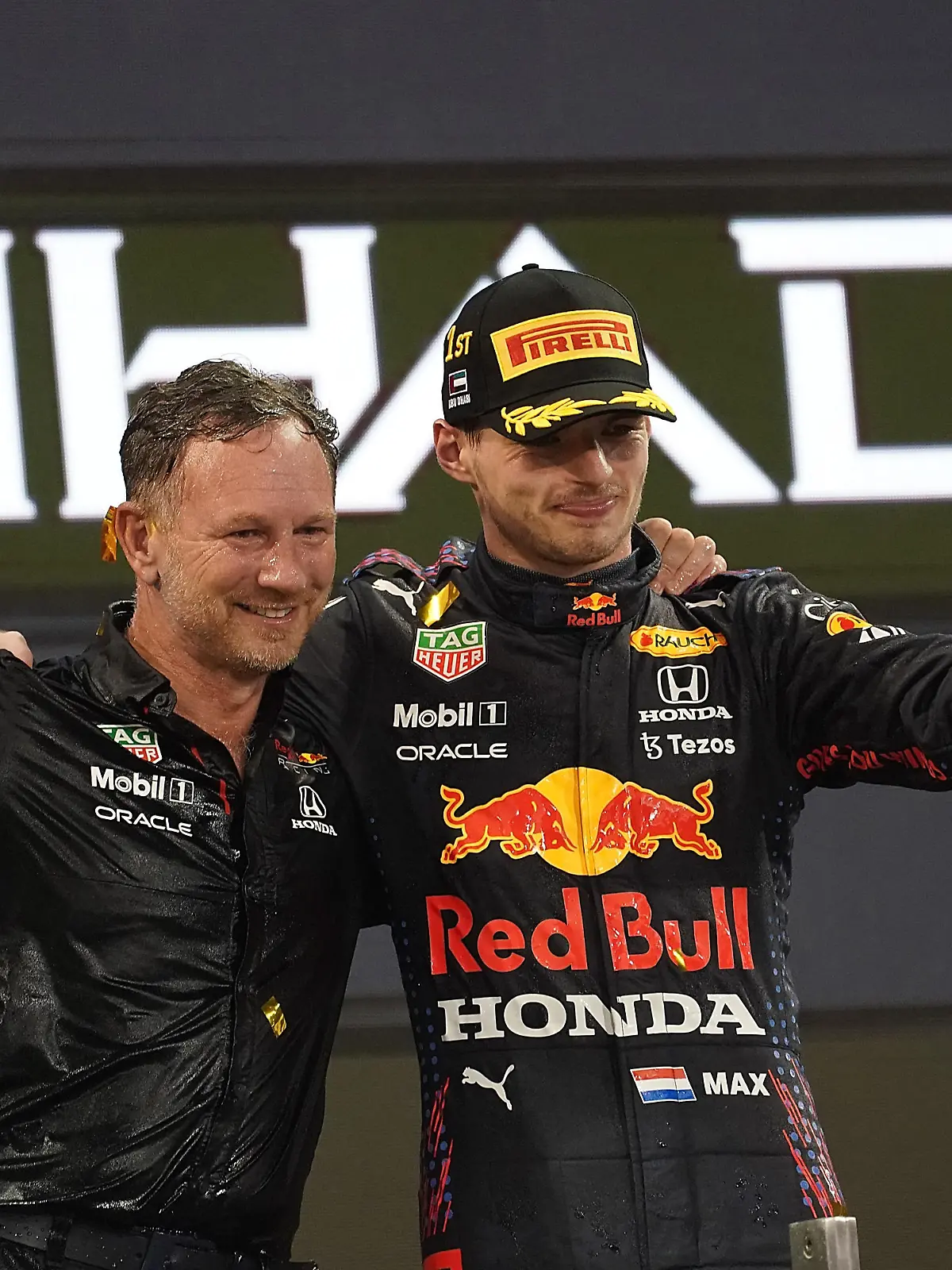 Motorsport: Formel-1-Weltmeisterschaft, Grand Prix von Abu Dhabi, Rennen. Max Verstappen (r) aus den Niederlanden vom Team Red Bull jubelt mit Christian Horner, Teamchef von Red Bull Racing, auf dem Podium. Verstappen hat zum ersten Mal den Fahrertitel in der Formel 1 geholt und Rekordweltmeister Hamilton entthront.