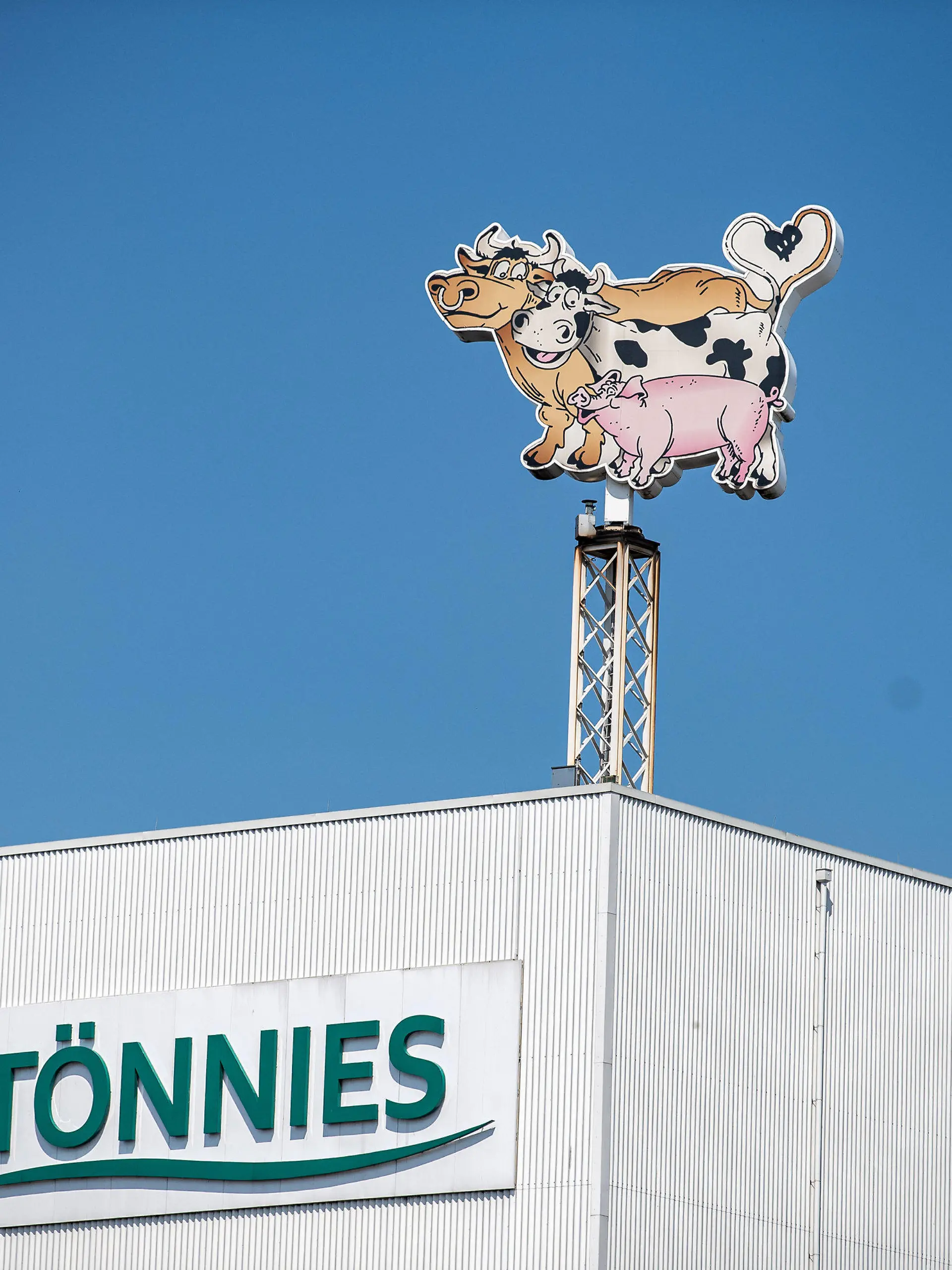 ARCHIV - 23.06.2020, Nordrhein-Westfalen, Rheda-Wiedenbrück: Auf dem Dach des Werksgeländes steht das Logo der Firma Tönnies in Form von zwei Kühen und einem Schwein. Der Gütersloher Landrat Adenauer rechnet nicht mit einem kurzfristigen Hochfahren der Produktion im Schlachtbetrieb von Tönnies in Rheda-Wiedenbrück. Foto: Guido Kirchner/dpa +++ dpa-Bildfunk +++