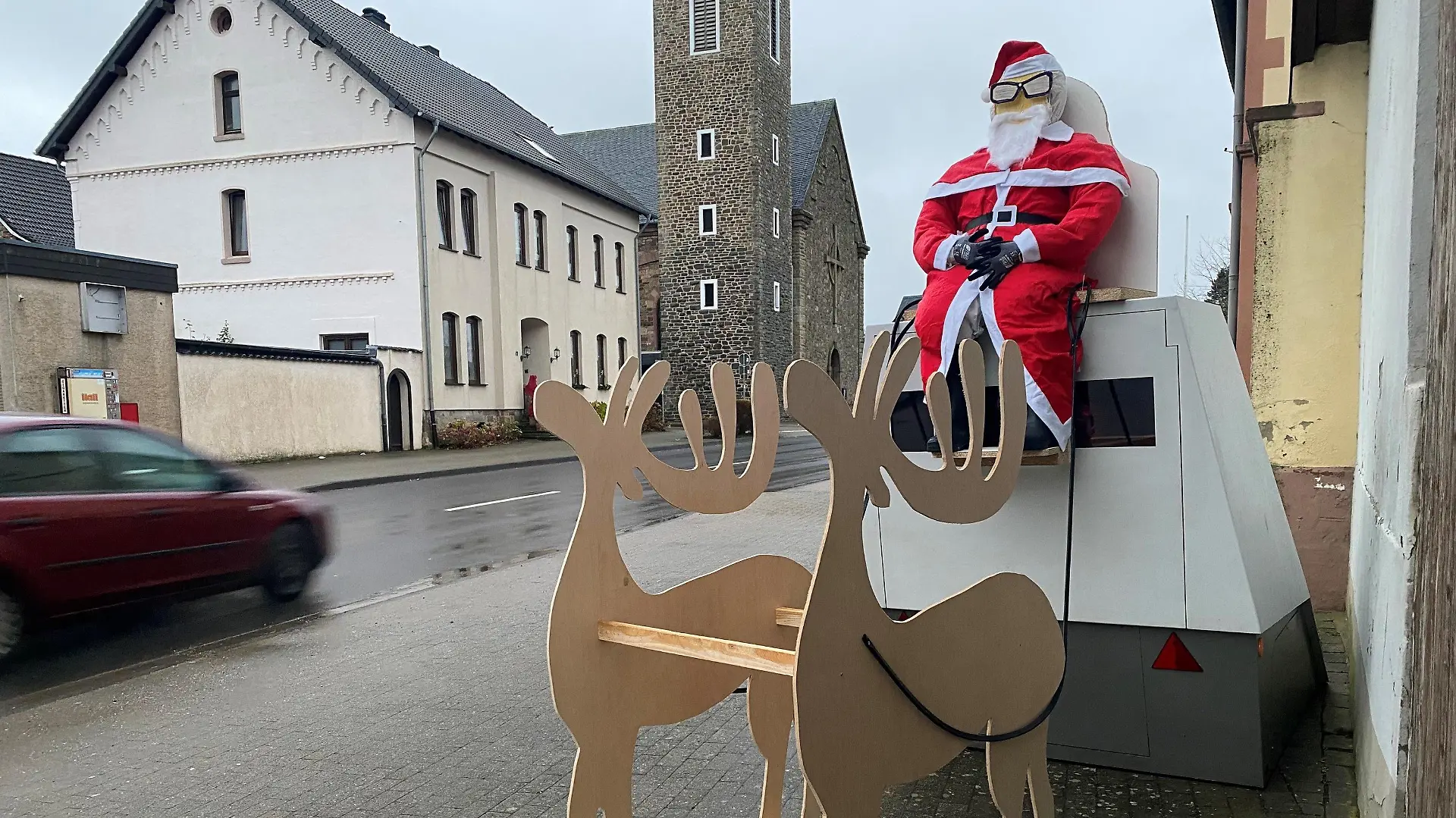 13.12.2021, Nordrhein-Westfalen, Hürtgenwald: Eine mobile Radarfalle dekoriert mit einem Weihnachtsmann und einem Schlitten steht in Hürtgenwald (Kreis Düren). Unbekannte hatten das Arrangement in der Nacht zu Montag angebracht. Foto: Lukas Weinberger/Medienhaus Aachen/dpa +++ dpa-Bildfunk +++