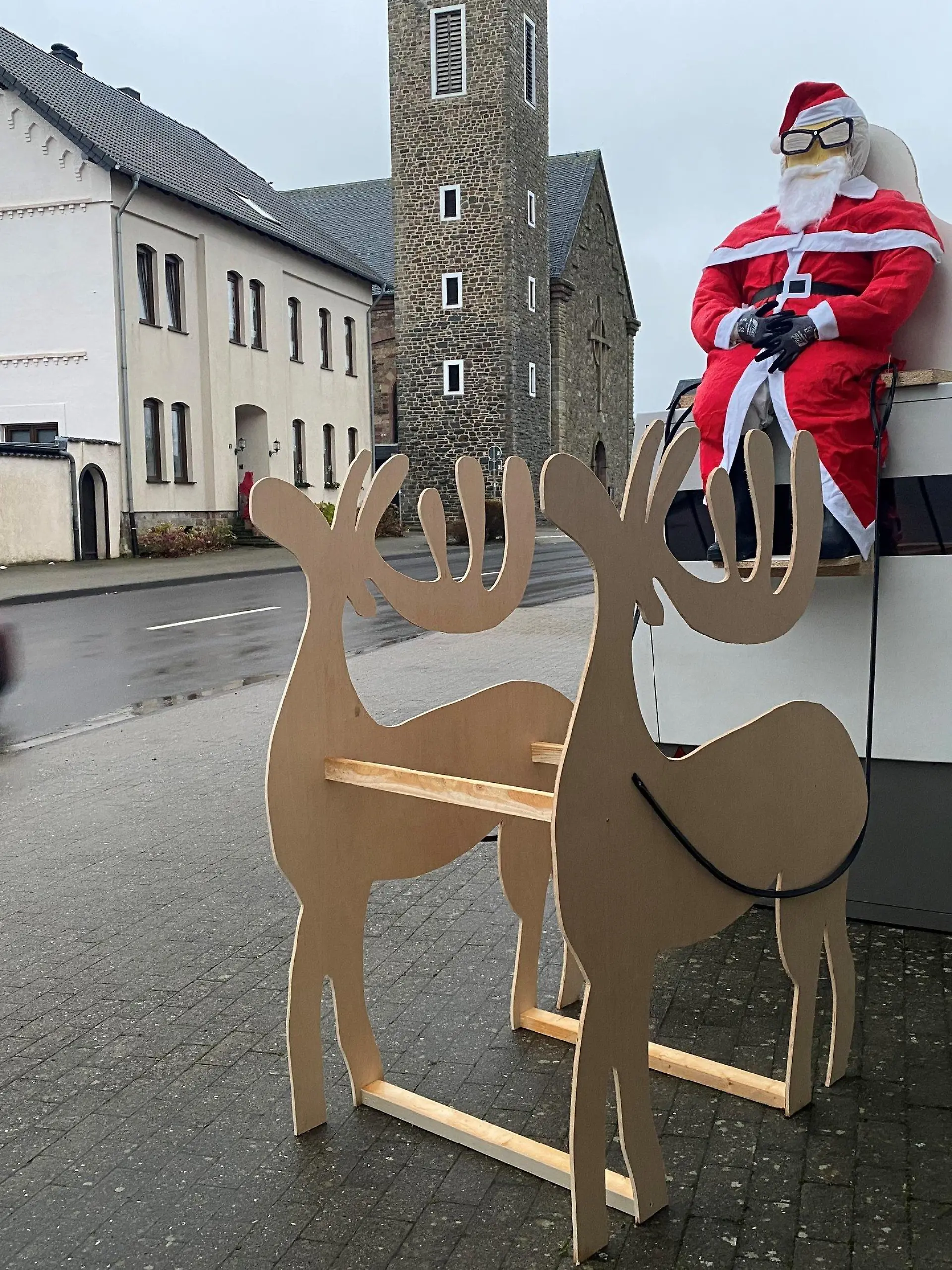 13.12.2021, Nordrhein-Westfalen, Hürtgenwald: Eine mobile Radarfalle dekoriert mit einem Weihnachtsmann und einem Schlitten steht in Hürtgenwald (Kreis Düren). Unbekannte hatten das Arrangement in der Nacht zu Montag angebracht. Foto: Lukas Weinberger/Medienhaus Aachen/dpa +++ dpa-Bildfunk +++