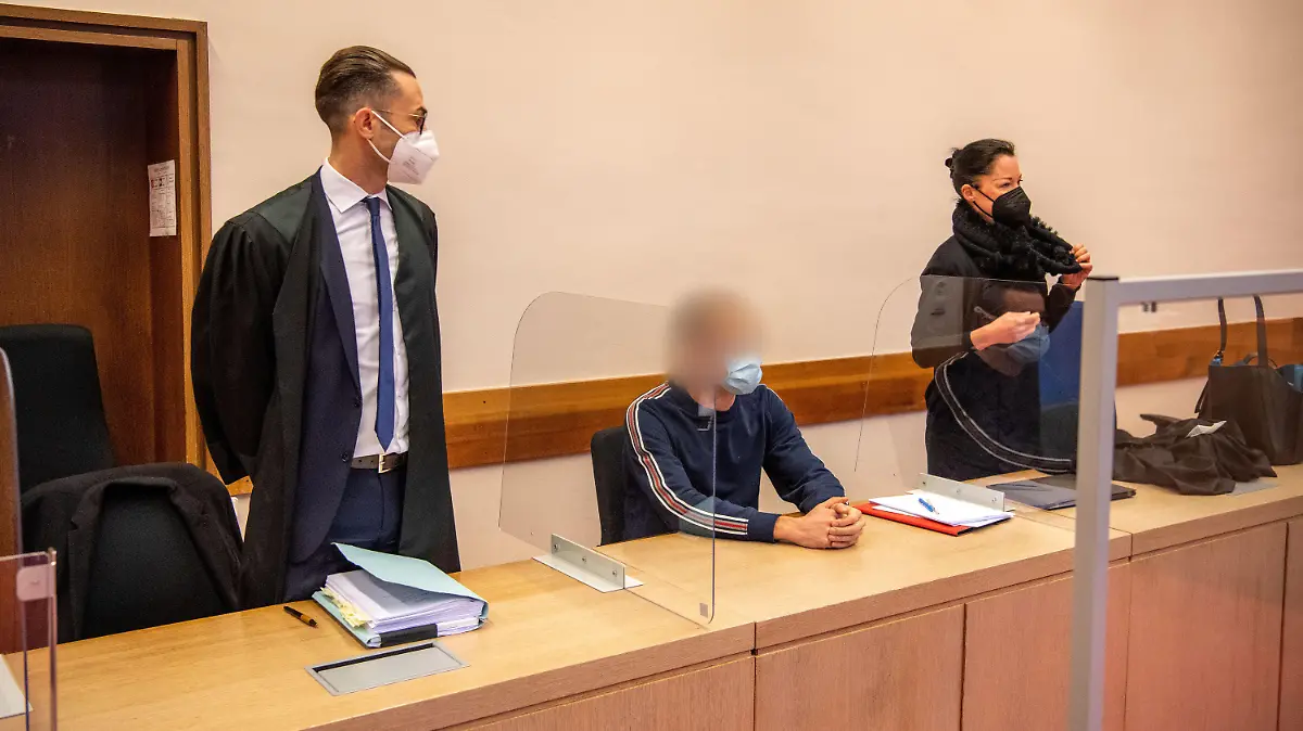 14.12.2021, Nordrhein-Westfalen, Detmold: Der Angeklagte (M) sitzt zwischen seinen Anwälten im Prozess um fahrlässige Körperverletzung durch eine fehlerhafte Zahn-Behandlung. Die Staatsanwaltschaft wirft dem 44-jährigen Angeklagten vor, eine damals 7-Jährige im September 2017 bei einer Zahnarztbehandlung falsch intubiert zu haben. Seit der Narkose, bei der der Sauerstoff in die Speise- und nicht in die Luftröhre geleitet worden sein soll, hatte das Kind einen irreparablen Hirnschaden. Den Fehler bei der Behandlung mehrerer Milchzähne soll der Mediziner zu spät erkannt haben. Der 44-Jährige streitet dies ab und geht von einer Verkrampfung der Atemwege aus (Bronchospasmus). Foto: Lino Mirgeler/dpa - ACHTUNG: Person(en) wurde(n) aus rechtlichen Gründen gepixelt +++ dpa-Bildfunk +++