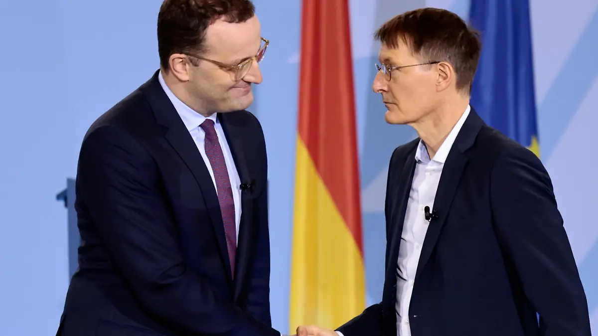 Germany's former Health Minister Jens Spahn shakes hands with the new Health Minister Karl Lauterbach during the handover ceremony in Berlin, Germany, December 8, 2021. REUTERS/Hannibal Hanschke/Pool