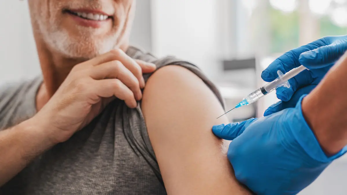Doctor making injection to senior patient in clinic