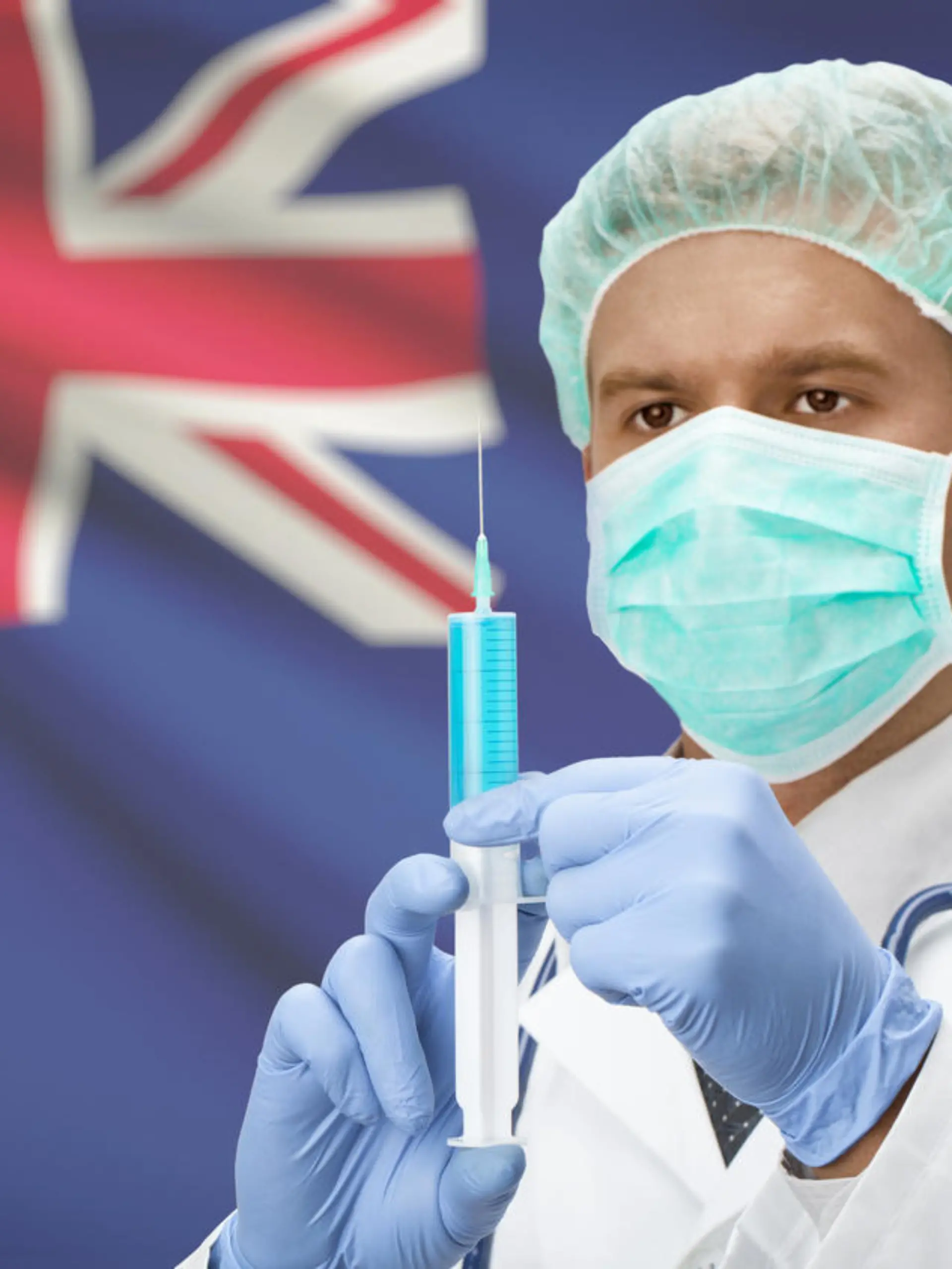 Doctor with syringe in hands and flag on background - New Zealand