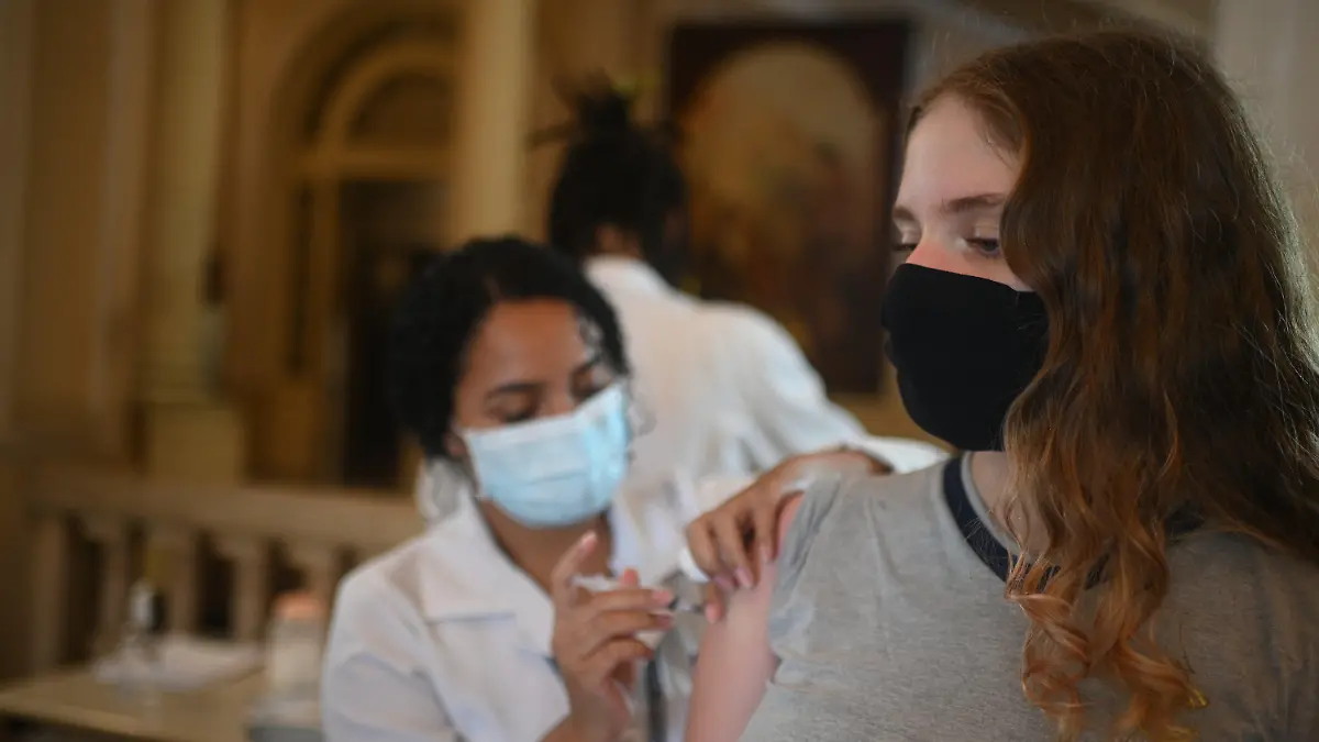 dpatopbilder - 17.11.2021, Brasilien, Rio De Janeiro: Teenager Elisa Scafuto Sterenberg, 13, erhält die zweite Dosis des Impfstoffs von Pfizer gegen Covid-19 in der Stadtverwaltung von Rio de Janeiro, in der sich eine Impfstelle gegen COVID-19 befindet. Foto: Andre Borges/dpa +++ dpa-Bildfunk +++