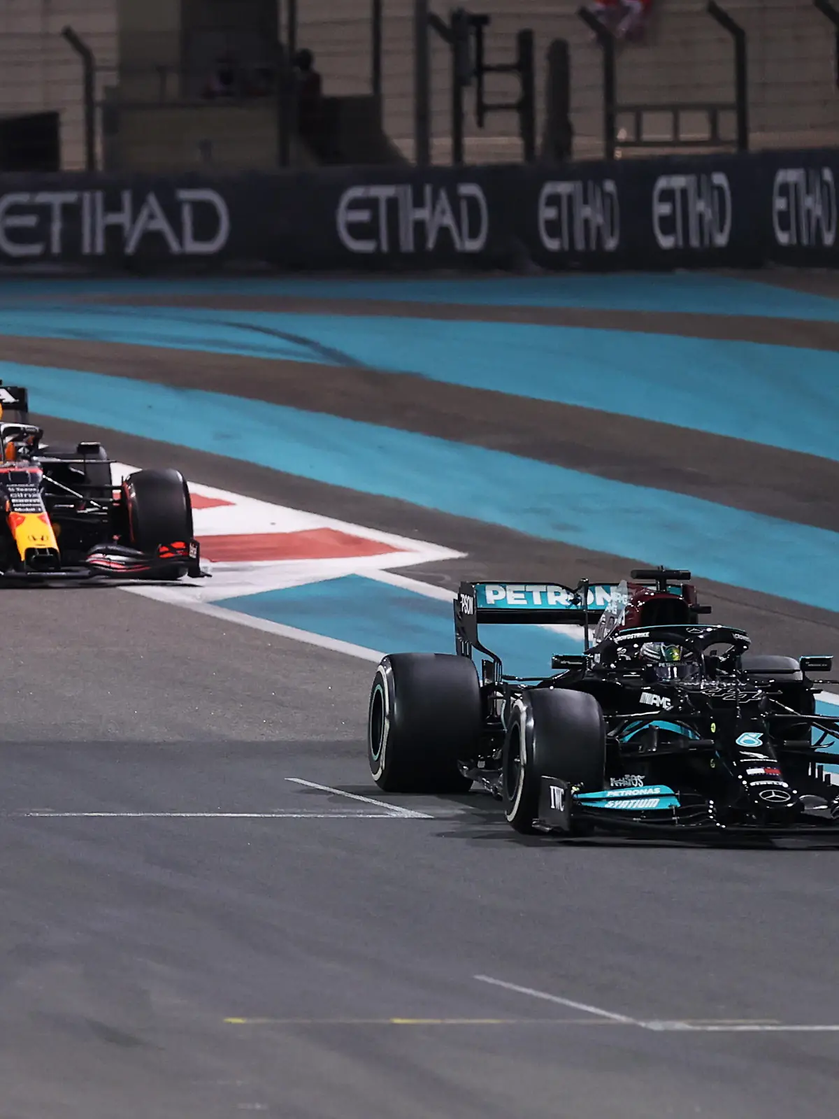 ABU DHABI, UNITED ARAB EMIRATES - DECEMBER 12: Lewis Hamilton of Great Britain driving the (44) Mercedes AMG Petronas F1 Team Mercedes W12 leads Max Verstappen of the Netherlands driving the (33) Red Bull Racing RB16B Honda at the safety car restart during the F1 Grand Prix of Abu Dhabi at Yas Marina Circuit on December 12, 2021 in Abu Dhabi, United Arab Emirates. (Photo by Lars Baron/Getty Images)