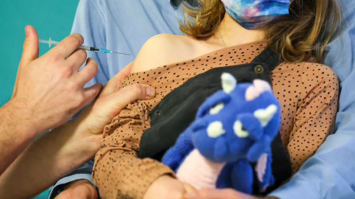 08.12.2021, Sachsen, Leipzig: Ein Kinderarzt impft ein 7-jähriges Mädchen gegen das Covid19-Virus. Die U12-Impfungen gehen in Sachsen langsam los. Die Empfehlung der Ständigen Impfkommission (Stiko) zu Corona-Schutzimpfungen für Kinder zwischen fünf und zwölf Jahre steht noch aus. Im Moment wird noch in einem so genannten ·off label use· der Erwachsenenimpfstoff extra für Kinder dosiert. Foto: Jan Woitas/dpa-Zentralbild/dpa +++ dpa-Bildfunk +++