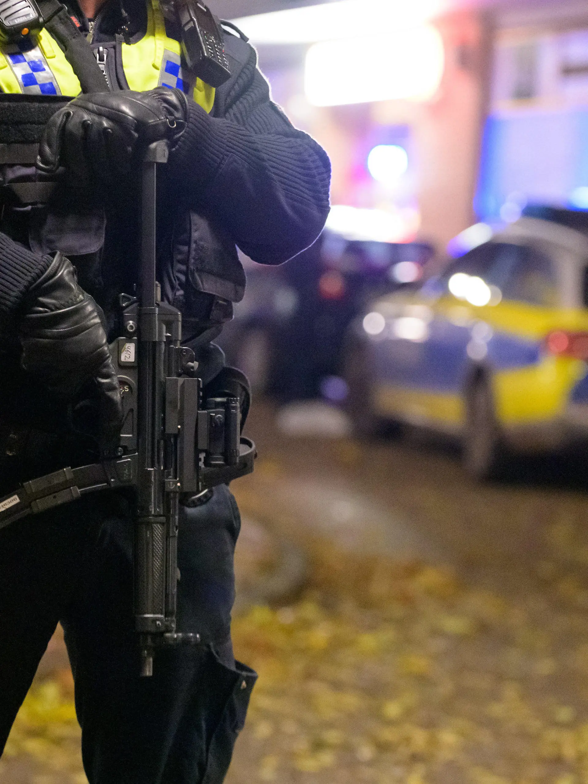 14.11.2021, Hamburg: Ein Polizist mit einer Maschinenpistole sichert einen abgesperrten Tatort. In Hamburg-Harburg sind am Sonntagnachmittag Schüsse gemeldet worden. Zwei Menschen seien möglicherweise verletzt, sagte ein Beamter beim Lagedienst der Polizei. Foto: Jonas Walzberg/dpa +++ dpa-Bildfunk +++
