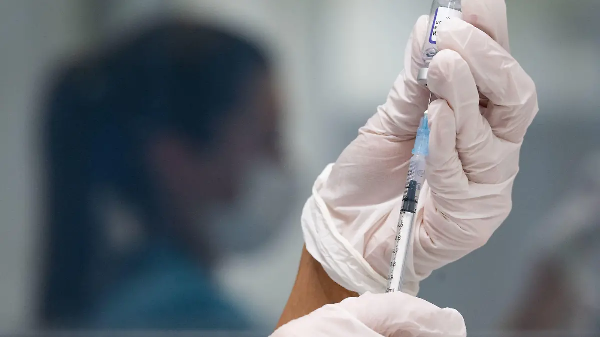 ARCHIV - 25.11.2021, Baden-Württemberg, Gerlingen: Eine Werksärztliche Assistentin zieht in einem betrieblichen Impfzentrum eine Dosis des Impfstoffes von Biontech/Pfizer auf. Mehrere Forscherteams haben in ersten Labortests festgestellt, dass Antikörper von Geimpften vergleichsweise schlecht auf die neue Omikron-Variante des Coronavirus ansprechen. (zu dpa «Hinweise aus dem Labor: Impfungen wohl weniger effektiv gegen Omikron») Foto: Marijan Murat/dpa +++ dpa-Bildfunk +++