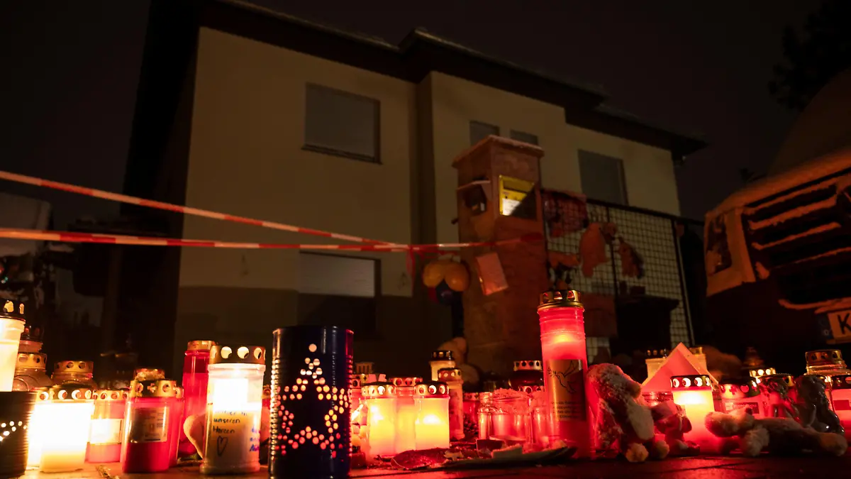 09.12.2021, Brandenburg, Königs Wusterhausen: Kerzen brennen auf einem Gehweg vor einem Einfamilienhaus in einem Ortsteil der Stadt Königs Wusterhausen im Landkreis Dahme-Spreewald. Polizisten hatten eine Familie tot in ihrem Wohnhaus im Königs Wusterhausener Ortsteil Senzig entdeckt. Foto: Christophe Gateau/dpa +++ dpa-Bildfunk +++