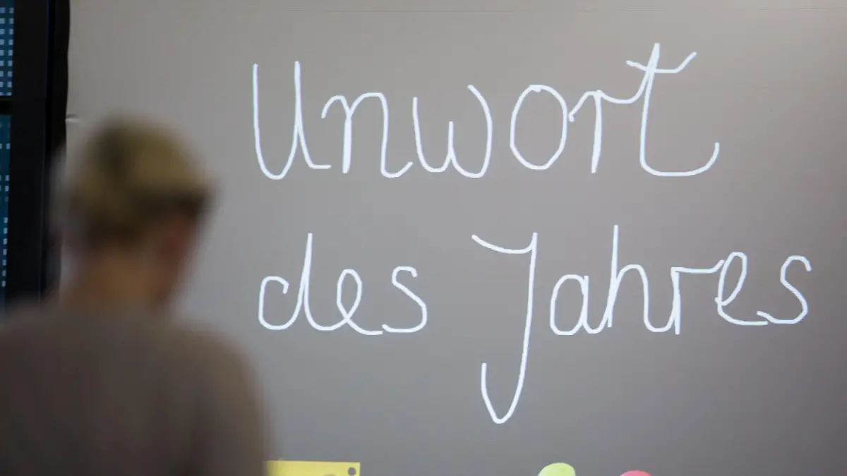 ARCHIV - 12.01.2016, Hessen, Darmstadt: "Unwort des Jahres" steht vor der Bekanntgabe des "Unwortes des Jahres 2015" auf einer Leinwand. (zu dpa - «Unwort des Jahres»: Begriffe rund um Corona-Pandemie im Fokus) Foto: Frank Rumpenhorst/dpa +++ dpa-Bildfunk +++