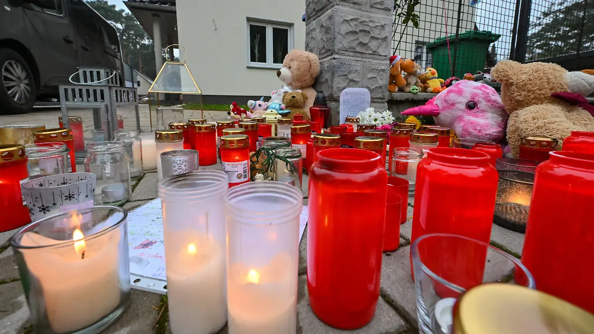 06.12.2021, Brandenburg, Senzig: Viele Kerzen brennen vor auf einem Gehweg vor einem Einfamilienhaus in einem Ortsteil der Stadt Königs Wusterhausen im Landkreis Dahme-Spreewald. Am 04.12.2021 hatten Zeugen in diesem Einfamilienhaus leblose Personen gesehen und die Polizei alarmiert. Die Beamten fanden die fünf Bewohner des Hauses tot vor. Darunter waren auch drei Kinder im Alter von 4, 8 und 10 Jahren, wie die Staatsanwaltschaft Cottbus und die Polizeidirektion Süd in einer gemeinsam Presseerklärung mitteilten. Die beiden Erwachsenen seien 40 Jahre alt gewesen. Foto: Patrick Pleul/dpa-Zentralbild/dpa - ACHTUNG: Namen wurden aus rechtlichen Gründen gepixelt +++ dpa-Bildfunk +++