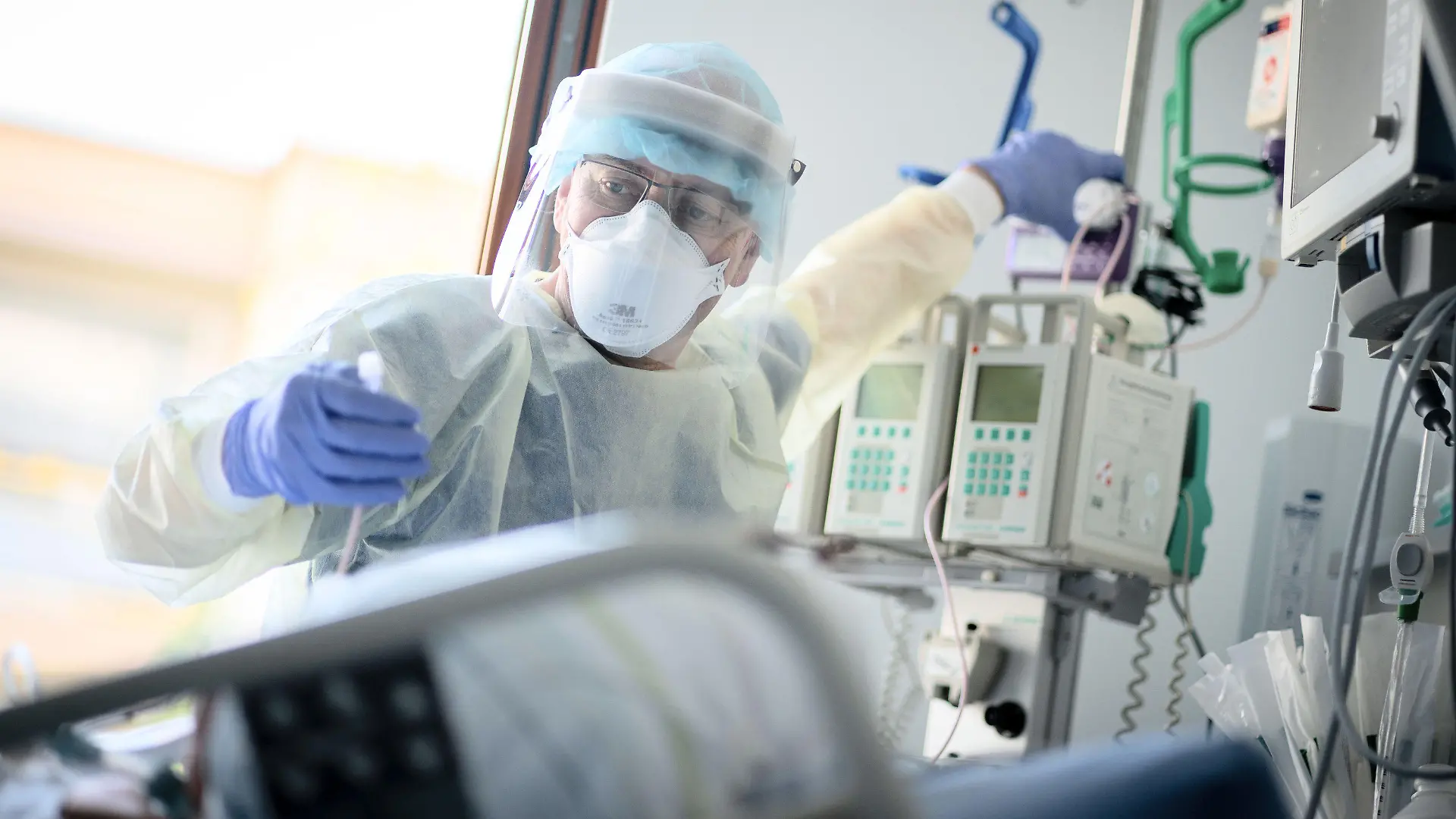 ARCHIV - 20.04.2021, Berlin: Intensivpfleger Rüdiger Piske arbeitet auf der Intensivstation des Krankenhauses Bethel Berlin an einer an Covid-19 erkrankten Patientin. Der Intensivmediziner Christian Karagiannidis rechnet wegen der sich zuspitzenden Corona-Lage damit, dass zunehmend Krankenhäuser wieder den Regelbetrieb einschränken. «Wir werden kaum darum herumkommen», sagte der wissenschaftliche Leiter des Intensivregisters der Deutschen Interdisziplinären Vereinigung für Intensiv- und Notfallmedizin. Foto: Kay Nietfeld/dpa +++ dpa-Bildfunk +++