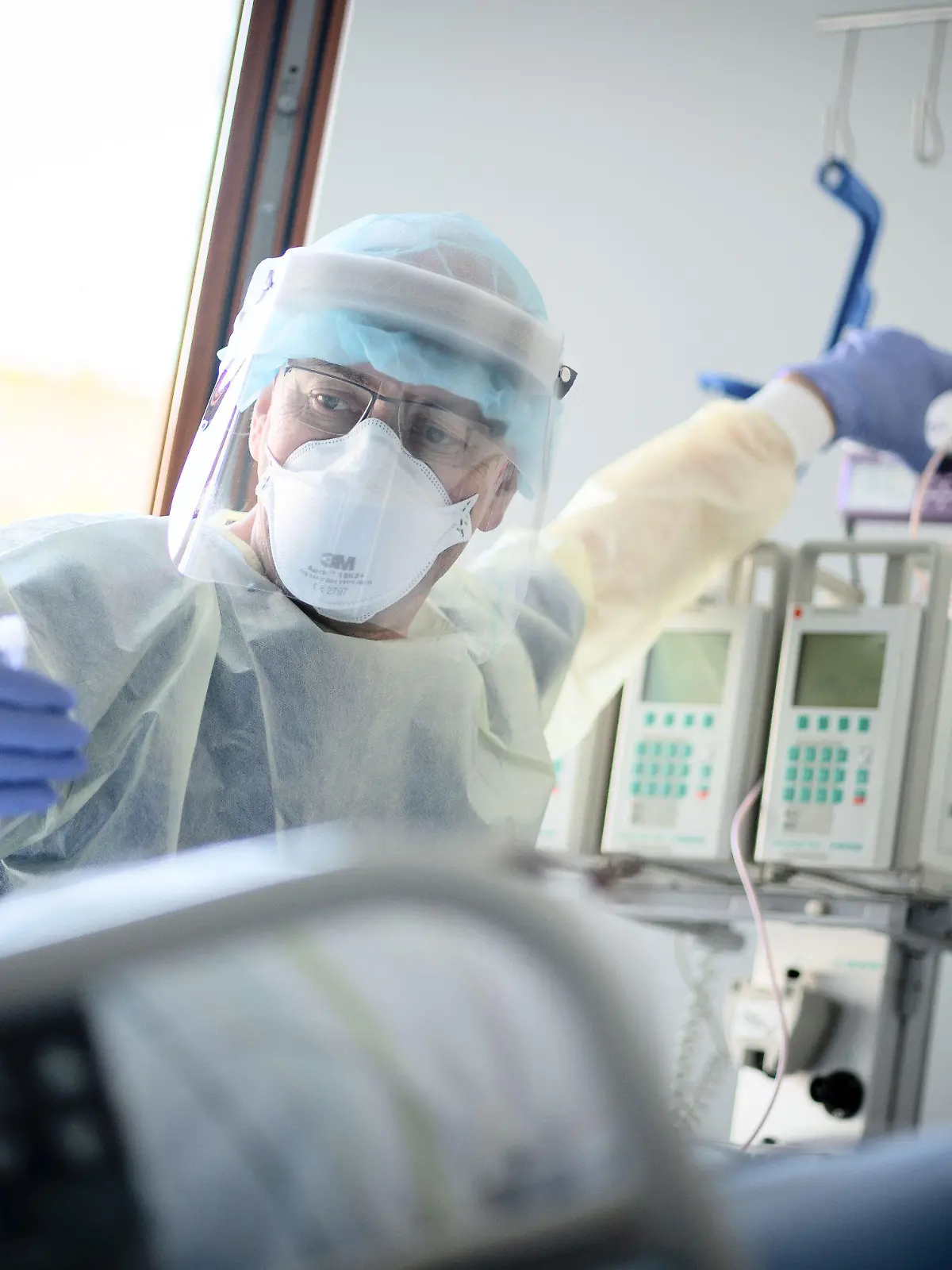 ARCHIV - 20.04.2021, Berlin: Intensivpfleger Rüdiger Piske arbeitet auf der Intensivstation des Krankenhauses Bethel Berlin an einer an Covid-19 erkrankten Patientin. Der Intensivmediziner Christian Karagiannidis rechnet wegen der sich zuspitzenden Corona-Lage damit, dass zunehmend Krankenhäuser wieder den Regelbetrieb einschränken. «Wir werden kaum darum herumkommen», sagte der wissenschaftliche Leiter des Intensivregisters der Deutschen Interdisziplinären Vereinigung für Intensiv- und Notfallmedizin. Foto: Kay Nietfeld/dpa +++ dpa-Bildfunk +++