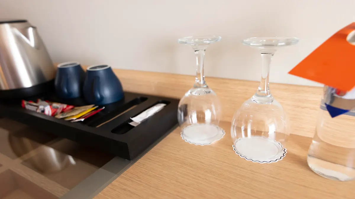 Cup of coffee placing on a wooden small table in hotel room