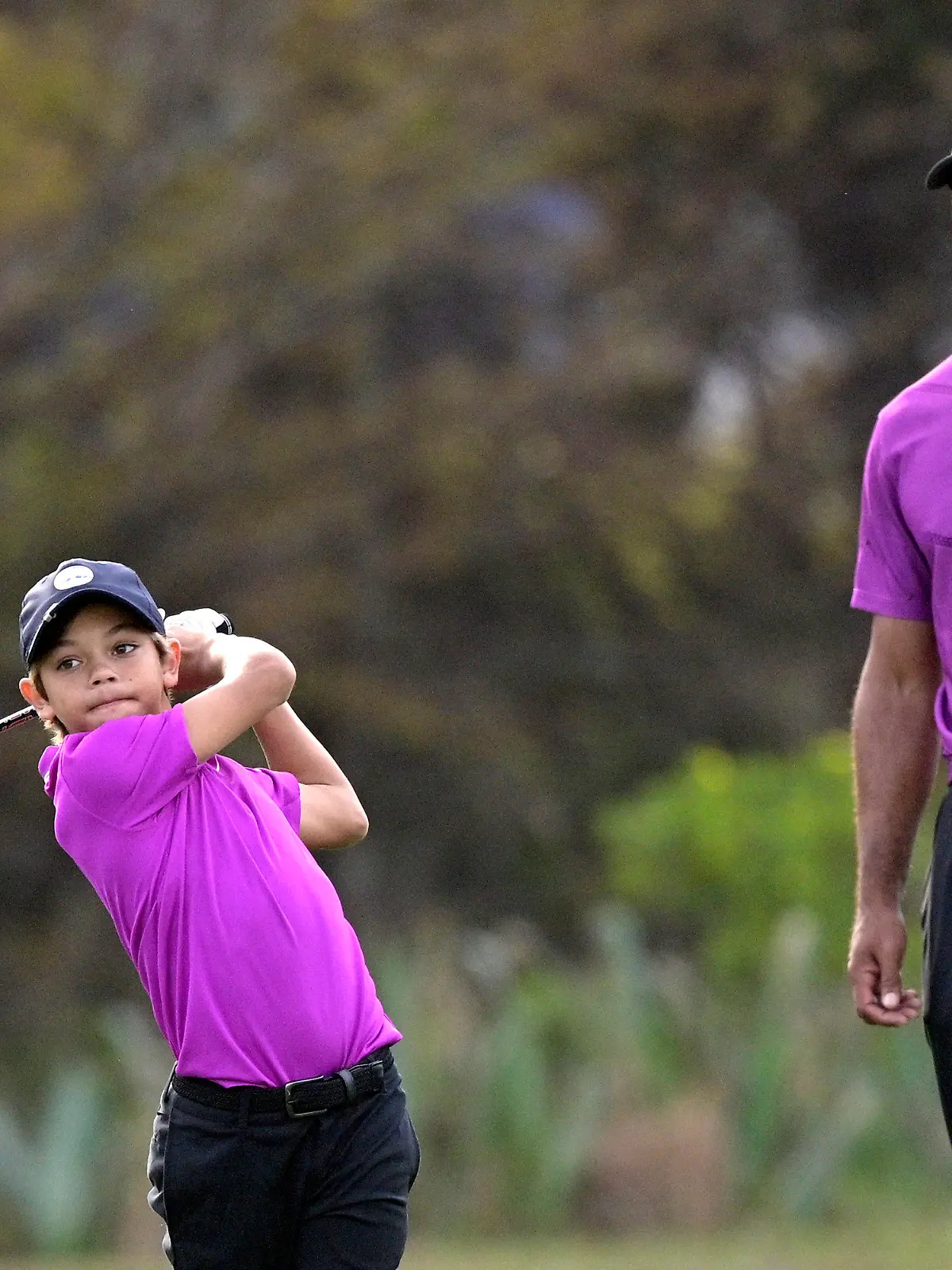 19.12.2020, USA, Orlando: Golf: PNC Championship, Erste Runde. Tiger Woods (r), beobachtet seinem Sohn Charlie beim Abschlag. Foto: Phelan M. Ebenhack/FR121174 AP/dpa +++ dpa-Bildfunk +++