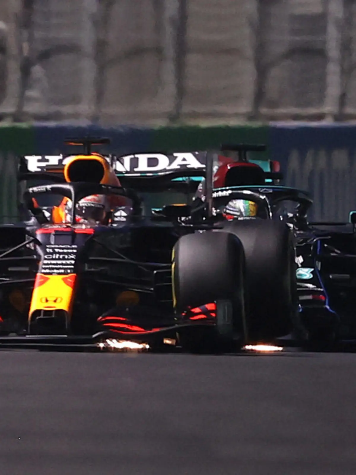 JEDDAH, SAUDI ARABIA - DECEMBER 05: Max Verstappen of the Netherlands driving the (33) Red Bull Racing RB16B Honda and Lewis Hamilton of Great Britain driving the (44) Mercedes AMG Petronas F1 Team Mercedes W12 collide during the F1 Grand Prix of Saudi Arabia at Jeddah Corniche Circuit on December 05, 2021 in Jeddah, Saudi Arabia. (Photo by Lars Baron/Getty Images)