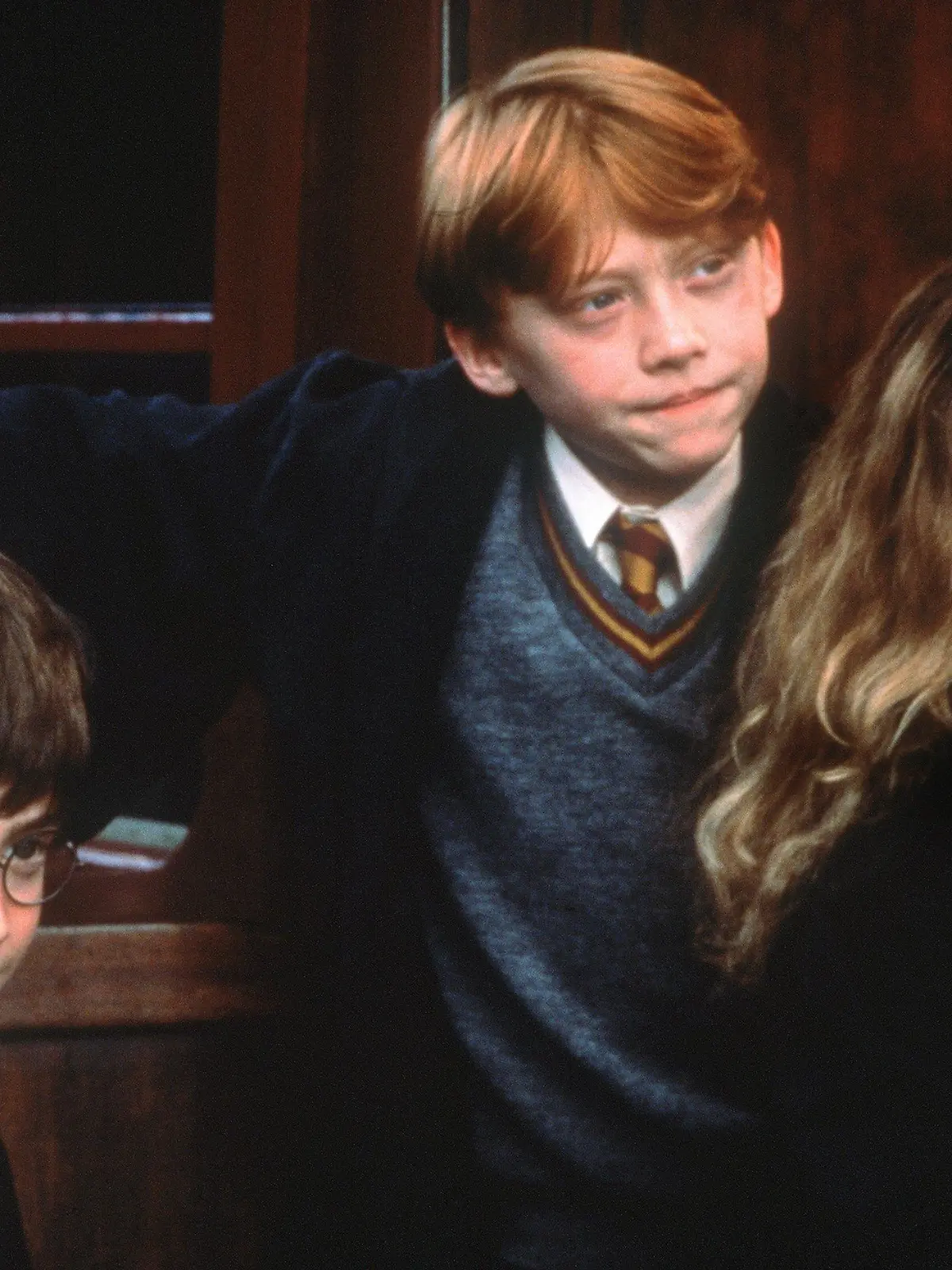ARCHIV - Voller Erwartung stehen die Zauberlehrlinge Harry Potter (Daniel Radcliffe, l.), Ron Weasley (Rupert Grint) und Hermine Granger (Emma Watson) im Kinofilm "Harry Potter und der Stein der Weisen" an der Tür zur Hogwarts-Schule für Zauberkunst (Szenenfoto, Illustration zum Thema Schuluniform). Harry Potter trägt die wohl bekannteste britische Schuluniform - nicht nur im Vereinigten Königreich würden Kinder gern das Wappen der Hogwart-Zaubererschule zur Schau stellen. Auch in vielen Ländern ohne Schuluniformpflicht dürften "Harry Potter"-Filme dazu beigetragen haben, den Gedanken an eine Identität fördernde Gemeinschaftskleidung für Kinder als "Botschafter" ihrer Schule zu fördern. Foto: Warner (zu dpa-Korr. "Das Supermodel für Schuluniformen ist ein Brite: Harry Potter" vom 10.05.2006) +++(c) dpa - Bildfunk+++