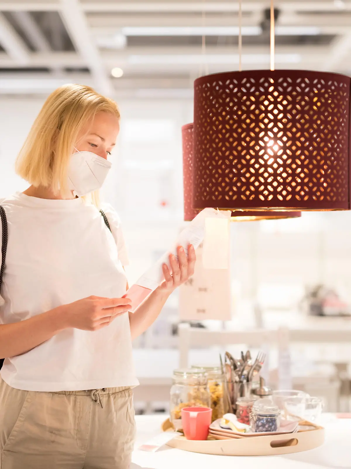 New normal during covid epidemic. Caucasian woman shopping at retail furniture and home accessories store wearing protective medical face mask to prevent spreading of corona virus. || Modellfreigabe vorhanden