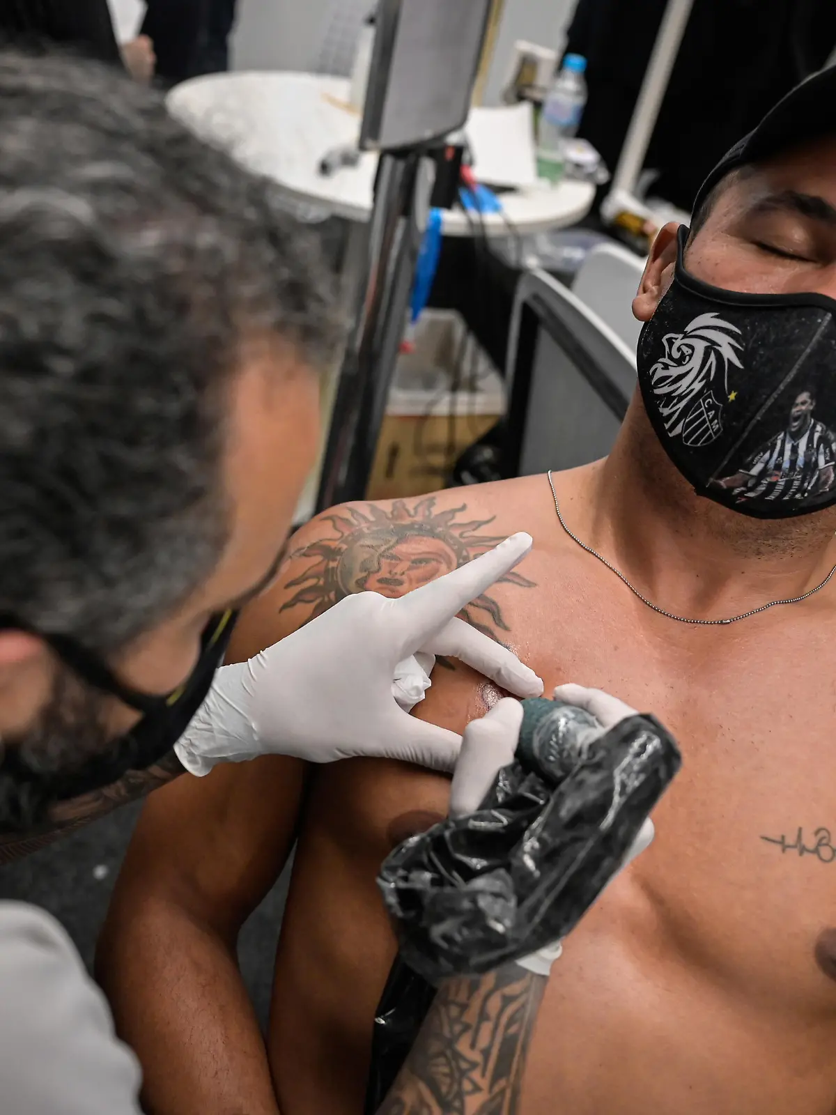 BELO HORIZONTE, BRAZIL - DECEMBER 06: A fan of Atletico Mineiro closes his eyes as getting a free tattoo the day after winning team's second Brazilian championship on December 6, 2021 in Belo Horizonte, Brazil. Almost 1000 people got tattooed with designs related to Atlético Mineiro, offered by the company MRV, the team's sponsor. (Photo by Pedro Vilela/Getty Images)