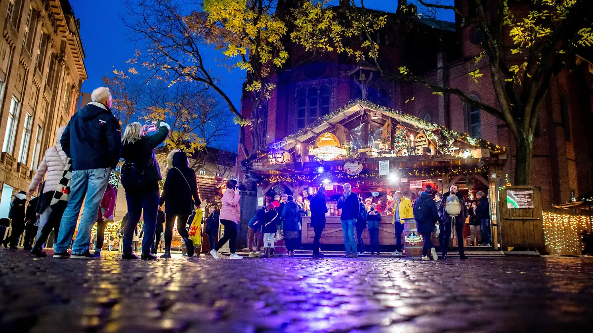 16.11.2021, Niedersachsen, Oldenburg: Zahlreiche Besucher gehen kurz nach der Eröffnung über den Lamberti-Markt. Auf dem Weihnachtsmarkt in der Innenstadt gilt eine 3G-Pflicht, deshalb kommen verschiedenfarbige Bändchen zum Einsatz, die die Gäste berechtigen, Speisen und Getränke zu kaufen. Foto: Hauke-Christian Dittrich/dpa +++ dpa-Bildfunk +++