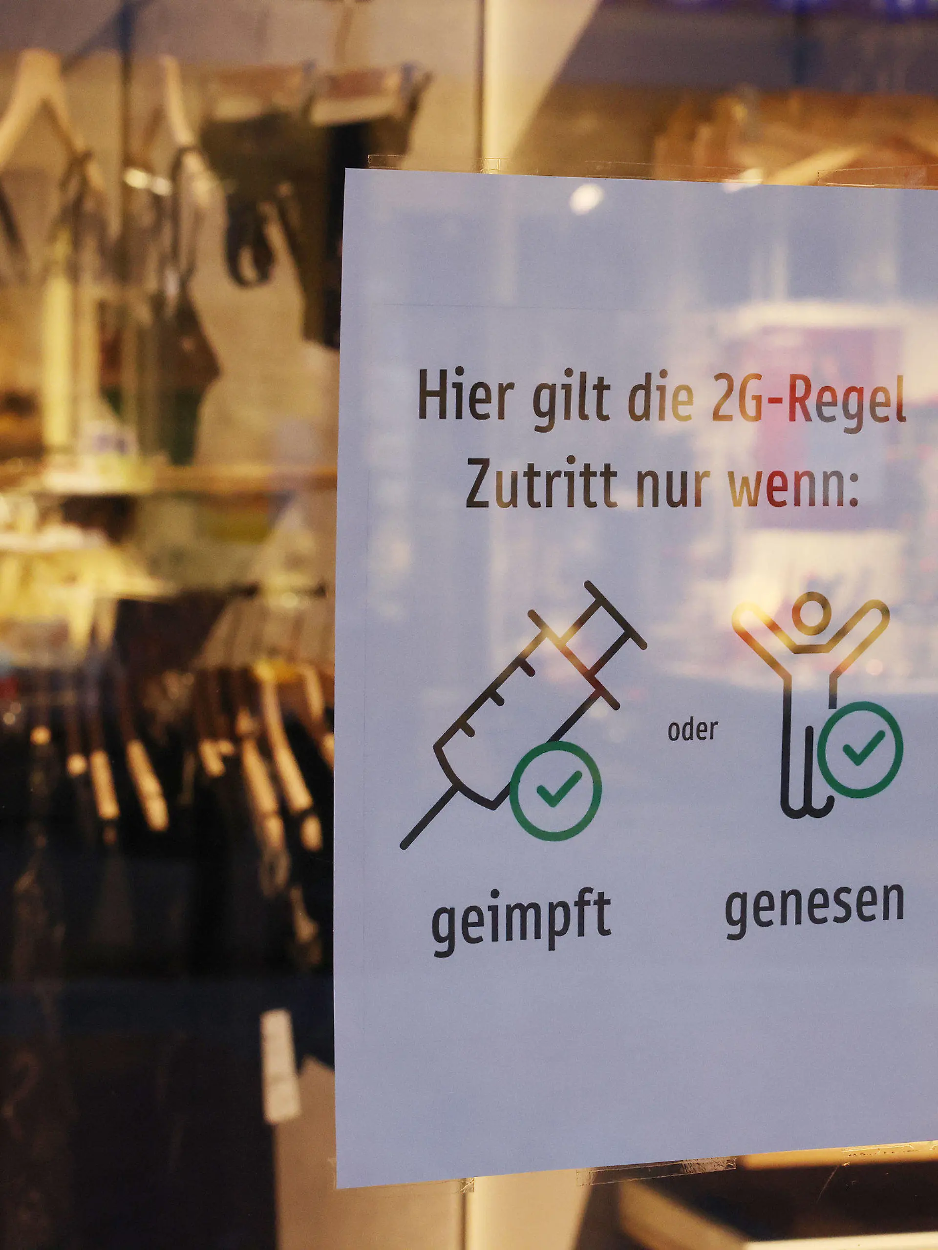 05.12.2021, Nordrhein-Westfalen, Bonn: Ein Schild in einem Schaufenster weist auf die 2G-Regel im Einzelhandel hin. In Nordrhein-Westfalen ist die Corona-Inzidenz wieder leicht angestiegen. Foto: Oliver Berg/dpa +++ dpa-Bildfunk +++