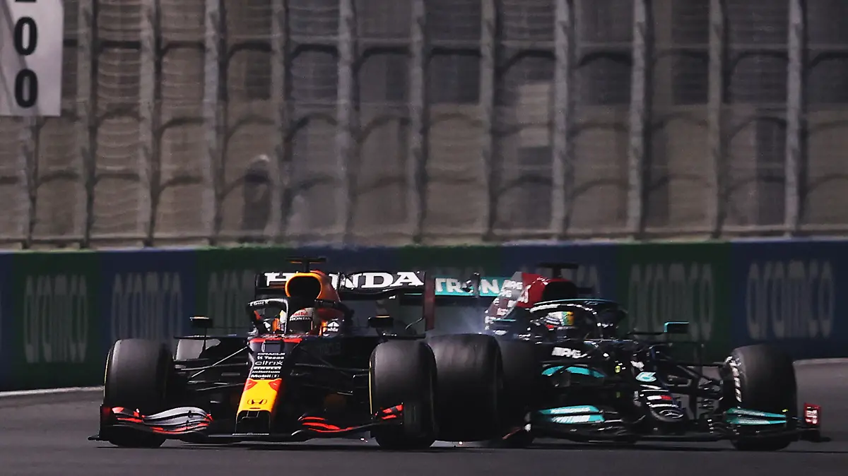 JEDDAH, SAUDI ARABIA - DECEMBER 05: Max Verstappen of the Netherlands driving the (33) Red Bull Racing RB16B Honda and Lewis Hamilton of Great Britain driving the (44) Mercedes AMG Petronas F1 Team Mercedes W12 collide during the F1 Grand Prix of Saudi Arabia at Jeddah Corniche Circuit on December 05, 2021 in Jeddah, Saudi Arabia. (Photo by Lars Baron/Getty Images)