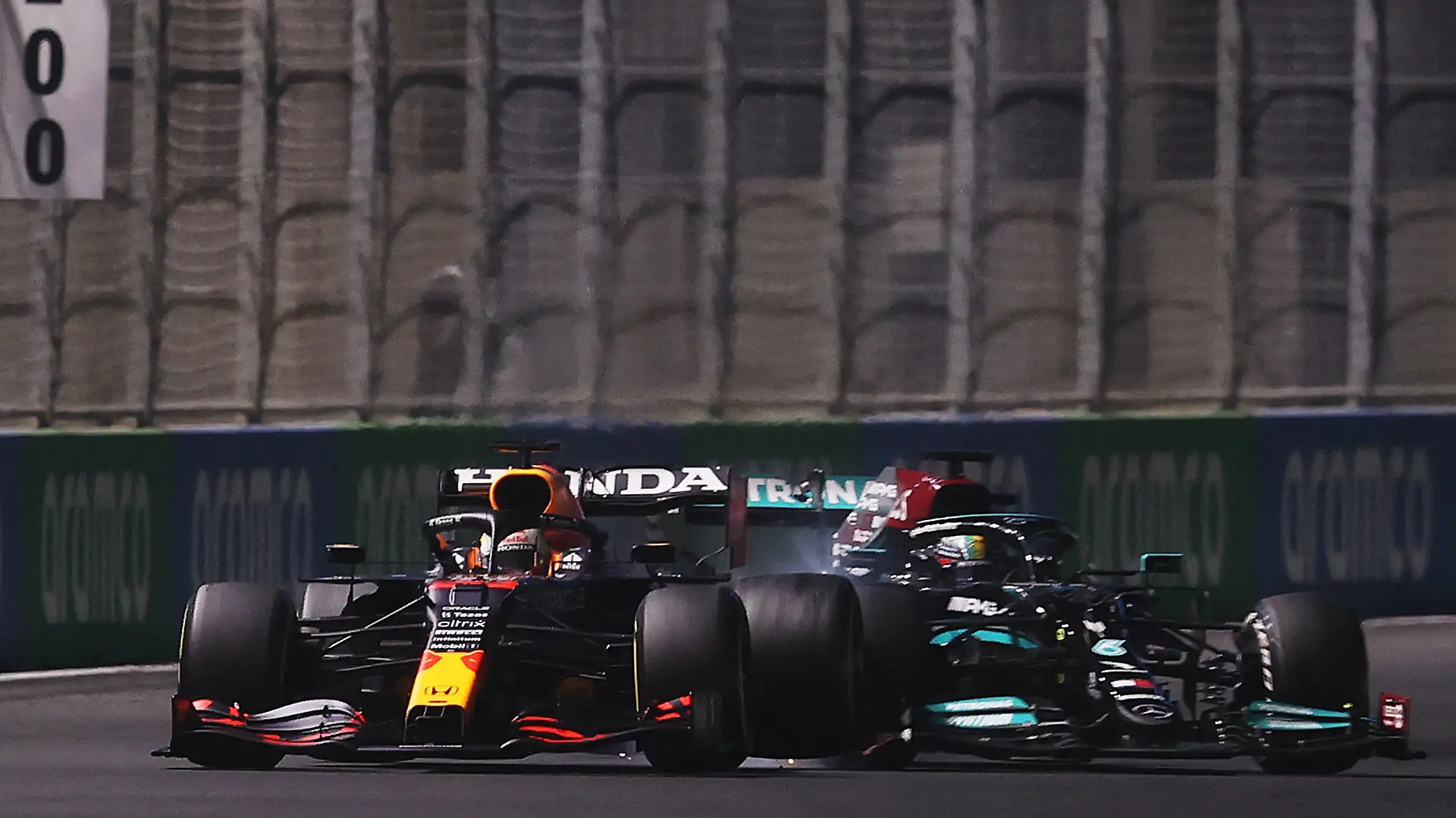 JEDDAH, SAUDI ARABIA - DECEMBER 05: Max Verstappen of the Netherlands driving the (33) Red Bull Racing RB16B Honda and Lewis Hamilton of Great Britain driving the (44) Mercedes AMG Petronas F1 Team Mercedes W12 collide during the F1 Grand Prix of Saudi Arabia at Jeddah Corniche Circuit on December 05, 2021 in Jeddah, Saudi Arabia. (Photo by Lars Baron/Getty Images)