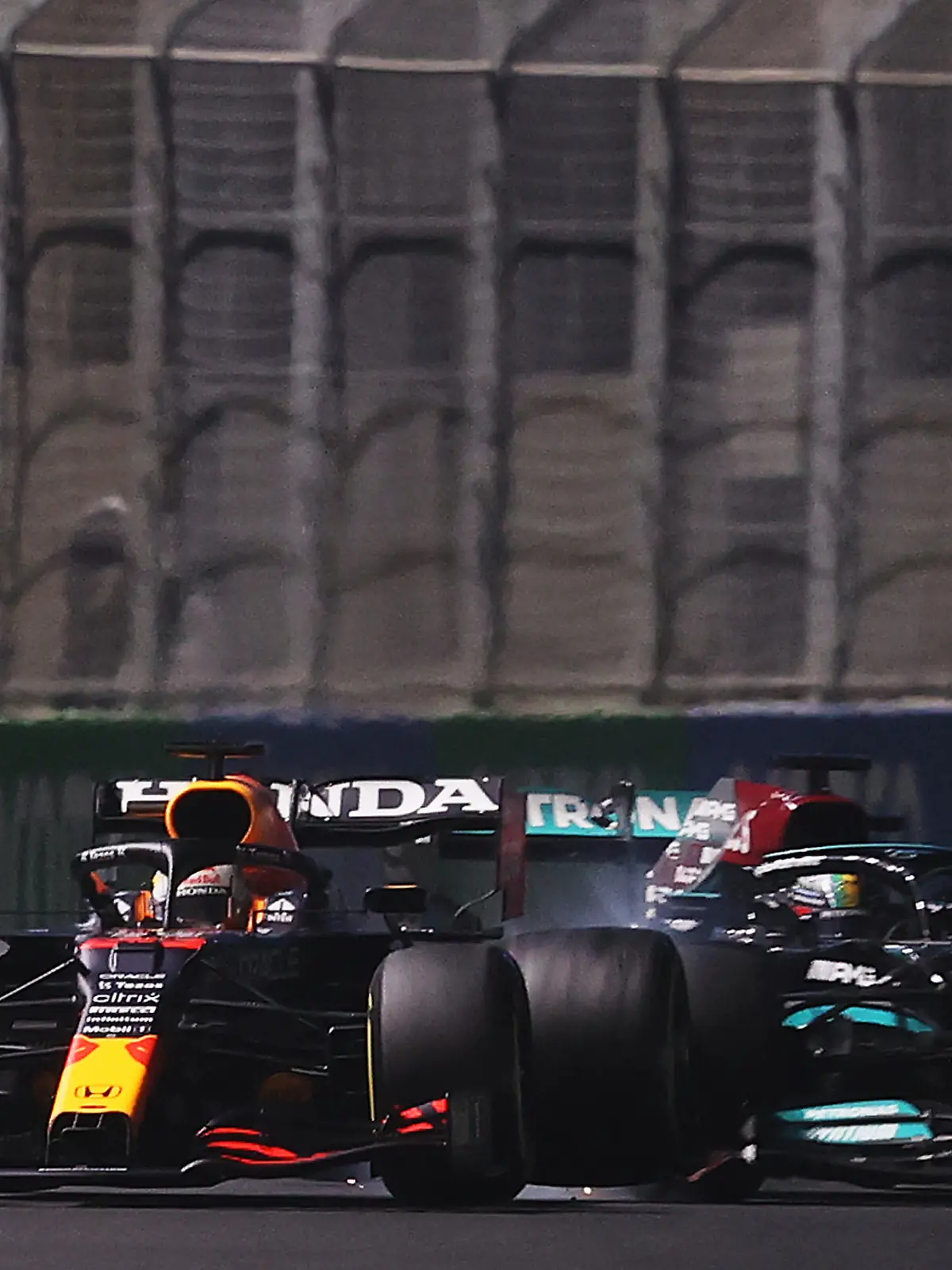 JEDDAH, SAUDI ARABIA - DECEMBER 05: Max Verstappen of the Netherlands driving the (33) Red Bull Racing RB16B Honda and Lewis Hamilton of Great Britain driving the (44) Mercedes AMG Petronas F1 Team Mercedes W12 collide during the F1 Grand Prix of Saudi Arabia at Jeddah Corniche Circuit on December 05, 2021 in Jeddah, Saudi Arabia. (Photo by Lars Baron/Getty Images)