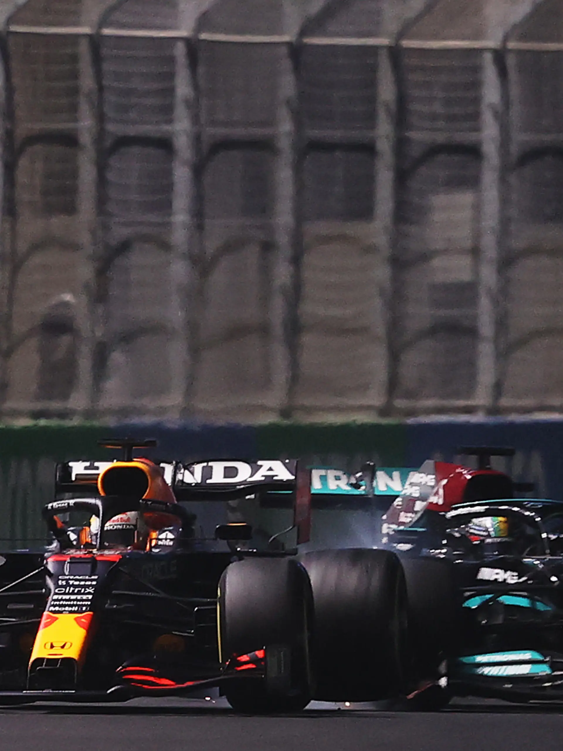JEDDAH, SAUDI ARABIA - DECEMBER 05: Max Verstappen of the Netherlands driving the (33) Red Bull Racing RB16B Honda and Lewis Hamilton of Great Britain driving the (44) Mercedes AMG Petronas F1 Team Mercedes W12 collide during the F1 Grand Prix of Saudi Arabia at Jeddah Corniche Circuit on December 05, 2021 in Jeddah, Saudi Arabia. (Photo by Lars Baron/Getty Images)