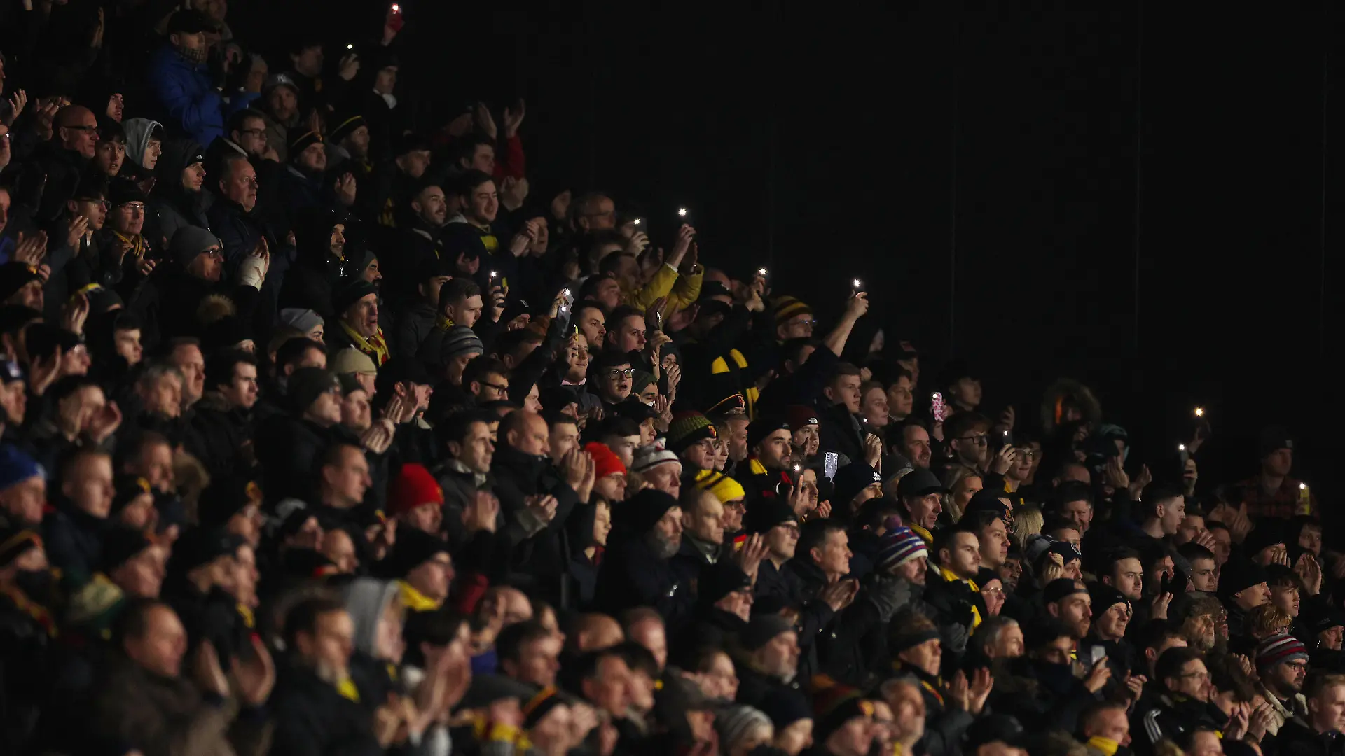 WATFORD, ENGLAND - DECEMBER 04: Fans of Watford hold a minutes applause in memory of Arthur Labinjo-Hughes during the Premier League match between Watford and Manchester City at Vicarage Road on December 04, 2021 in Watford, England. (Photo by Richard Heathcote/Getty Images)