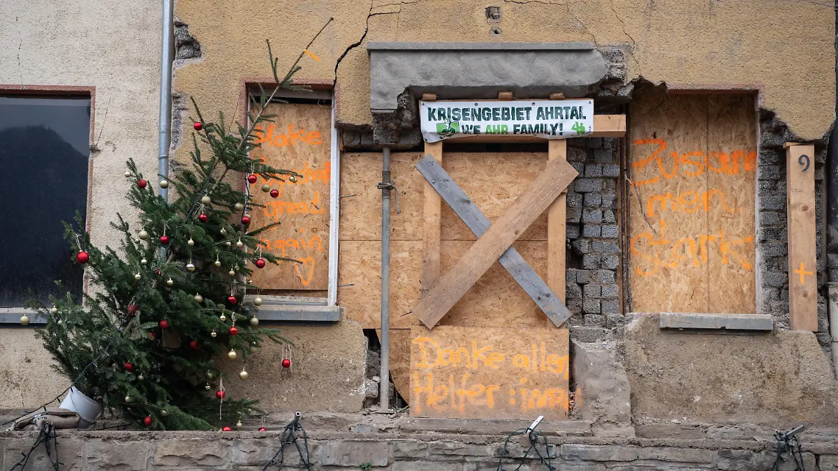28.11.2021, Rheinland-Pfalz, Mayschoß: Festlich geschmückte Weihnachtsbäume stehen in Mayschoß vor vernagelten Fenstern an menschenleeren Straßen. Der Ort ist von der Flutkatastrophe im Juli besonders stark betroffen. Foto: Boris Roessler/dpa +++ dpa-Bildfunk +++